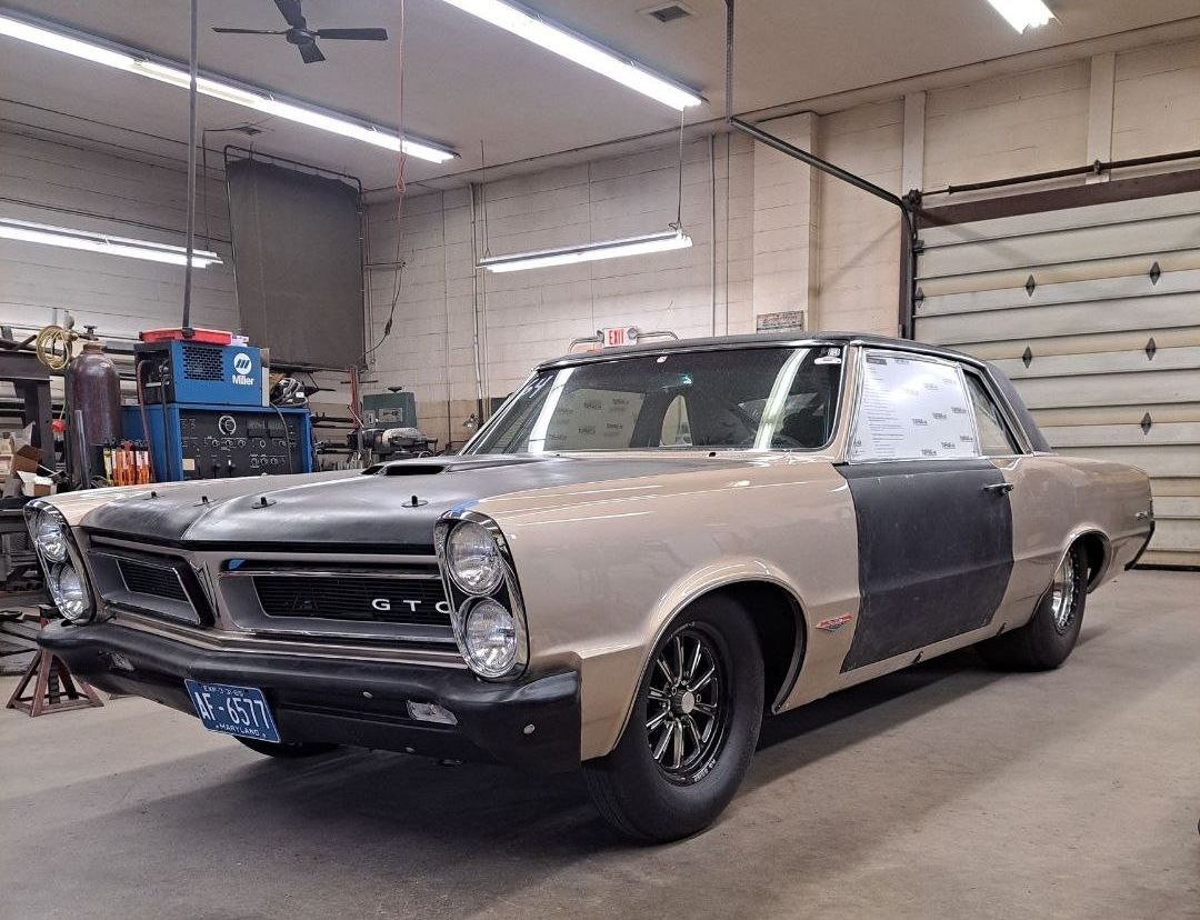 A car is parked in a garage next to a garage door.