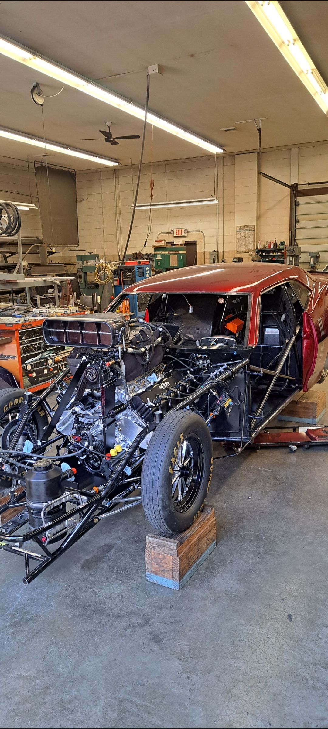 A red car is being built in a garage.