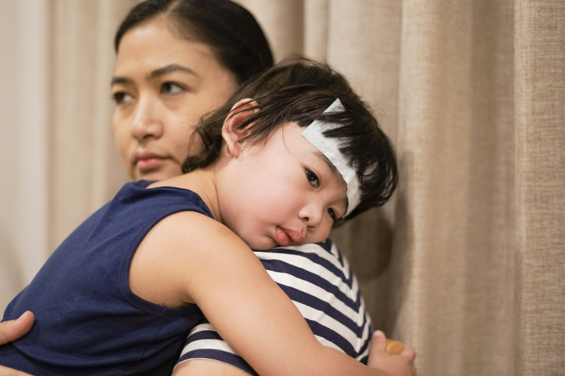 Lifestyle diseases manifest in a child being held by her mother, with symptoms indicating illness.