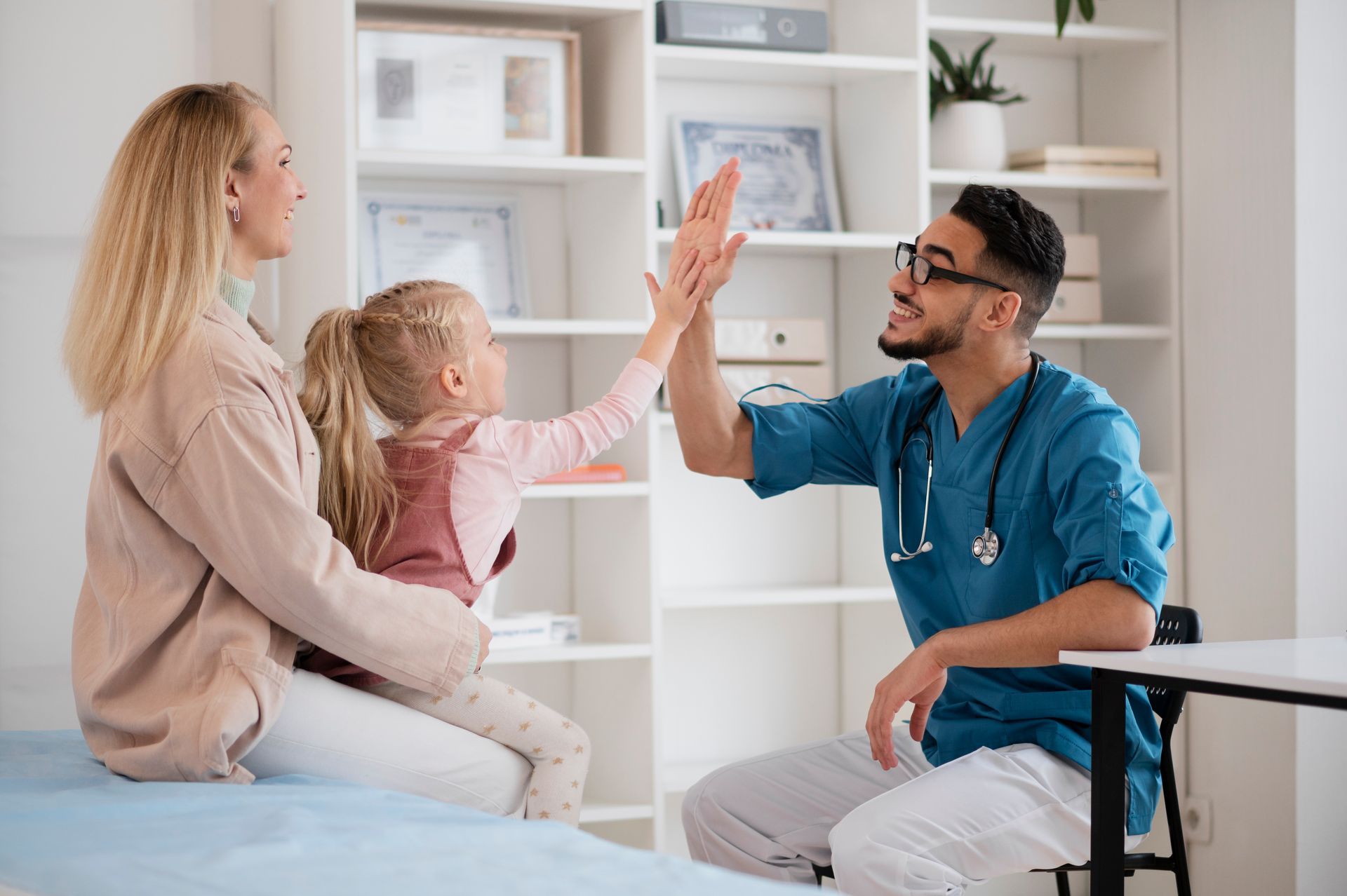 A doctor and a little girl are giving each other a high five.