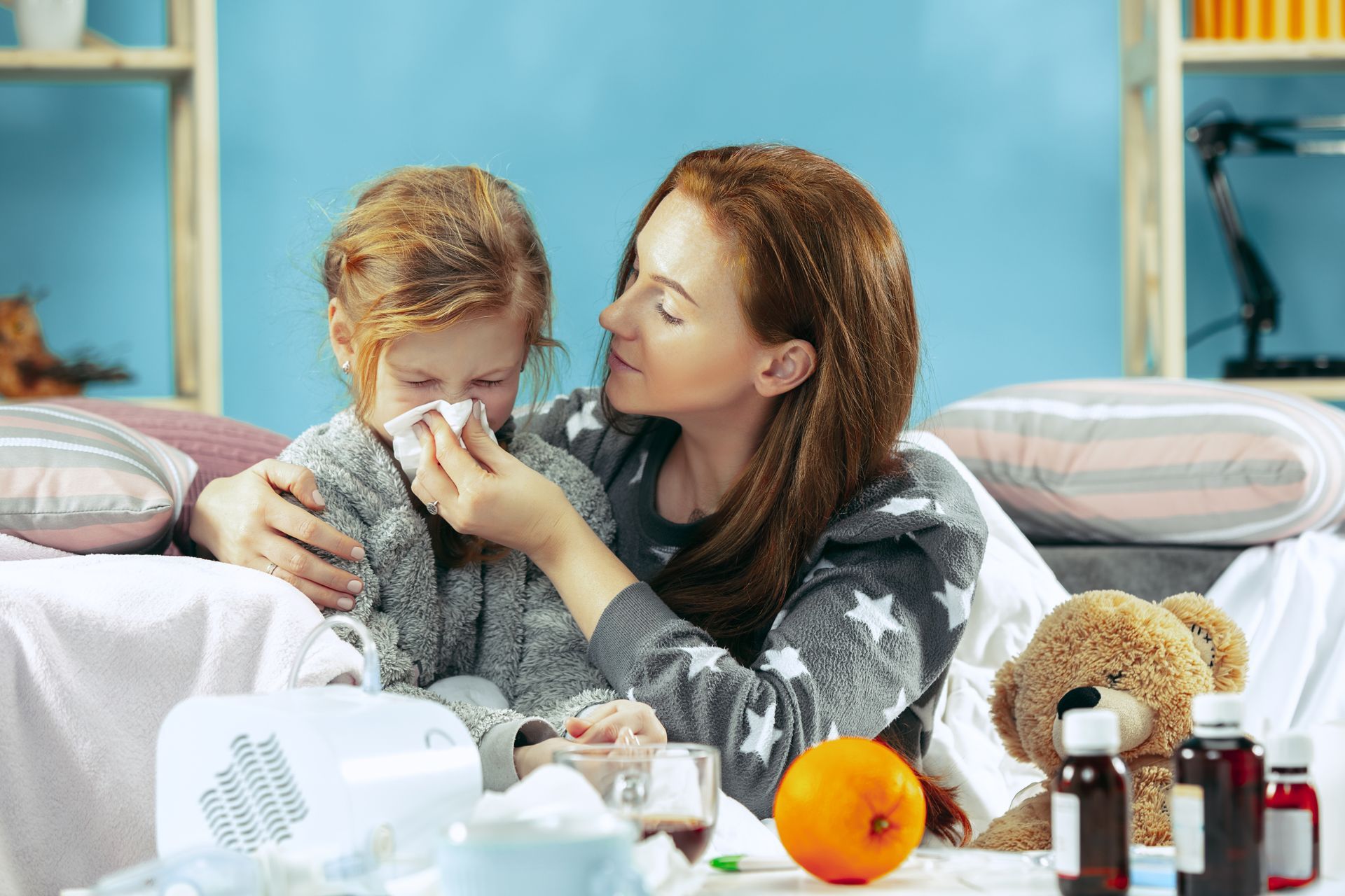 A woman is holding a sick child who is blowing his nose.