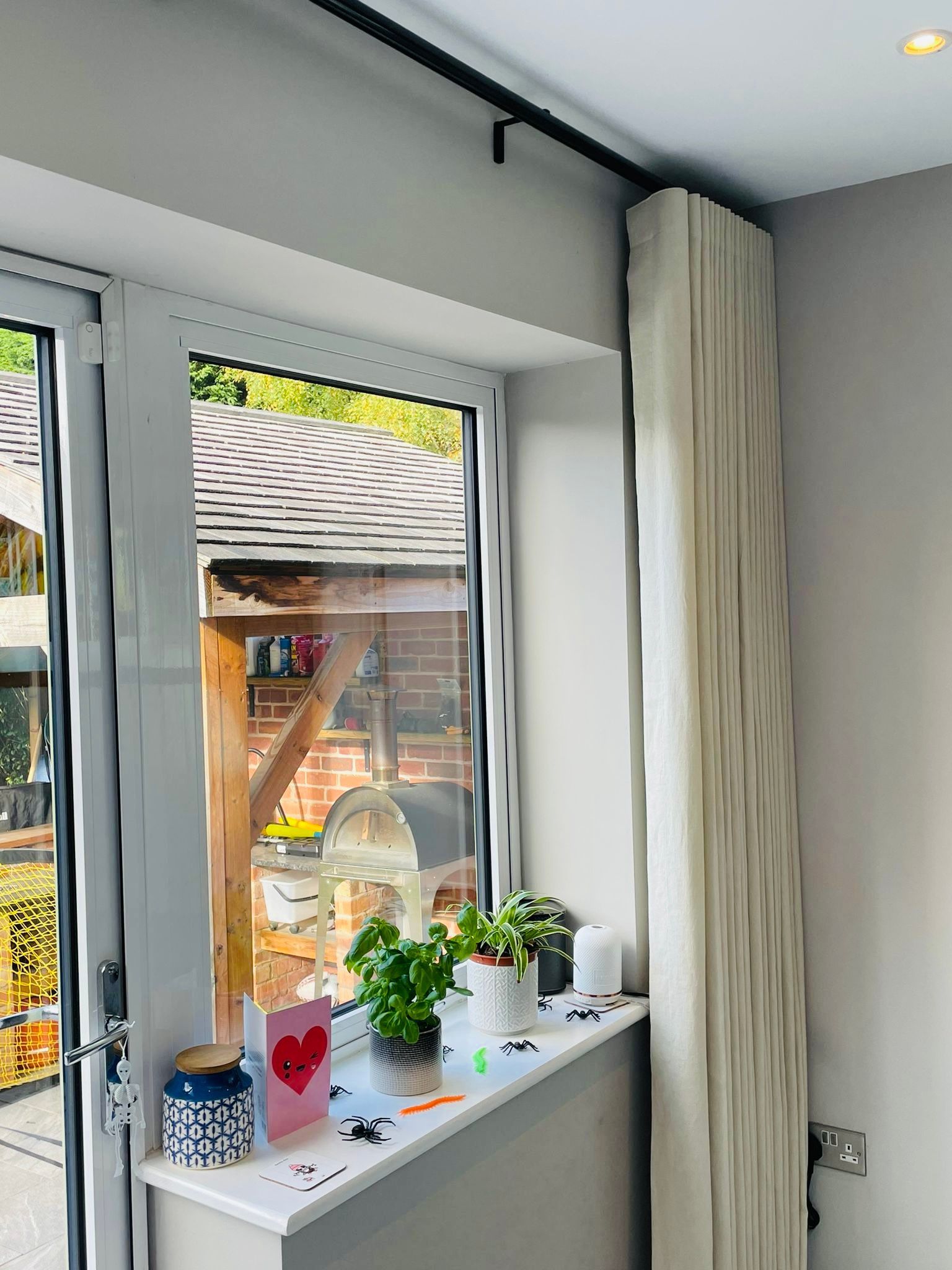 A window sill with potted plants and a card on it.