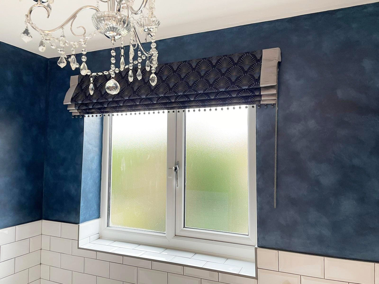 A bathroom with a window and a chandelier hanging from the ceiling.