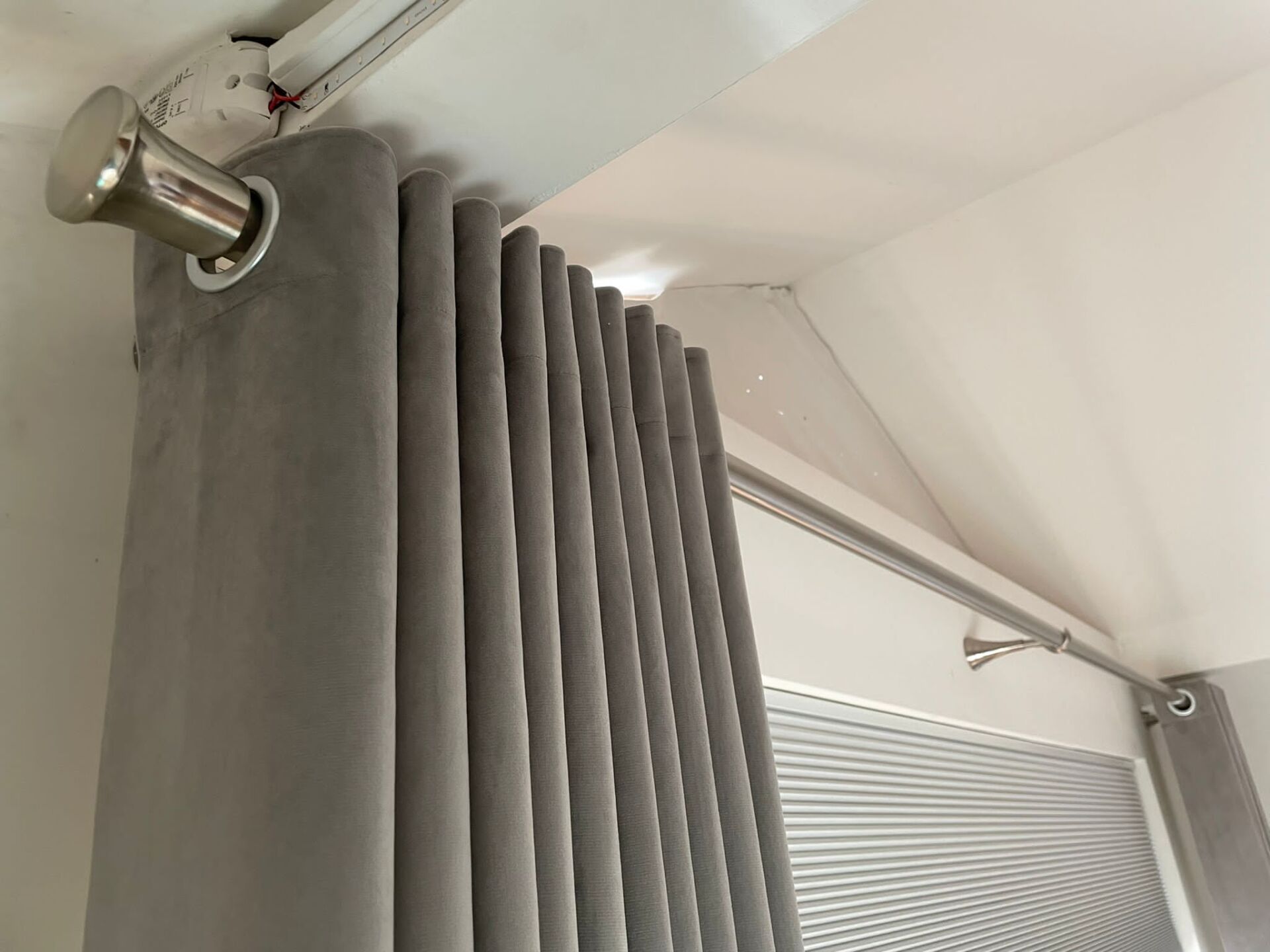 A close up of a pair of curtains hanging from the ceiling