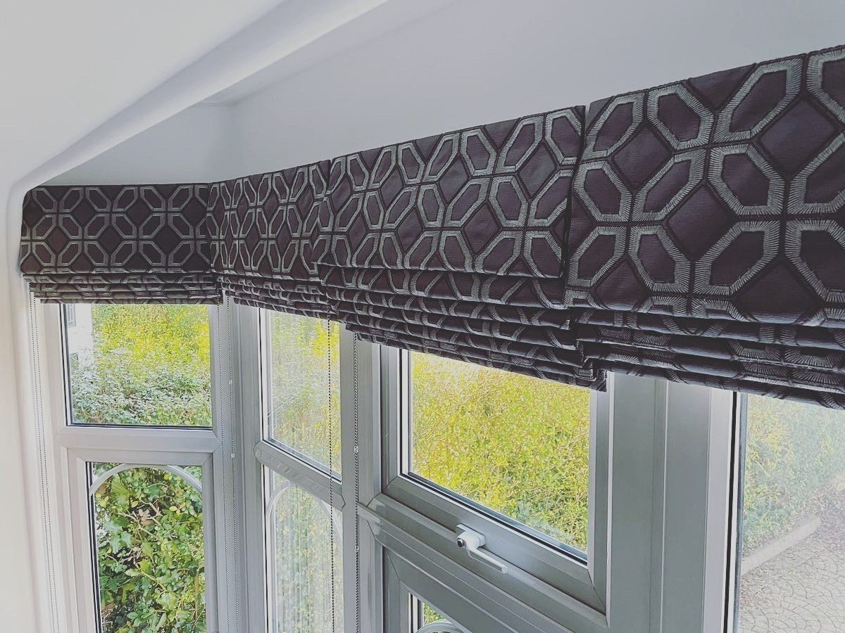 A window with a roman blind on it and a pattern on it.