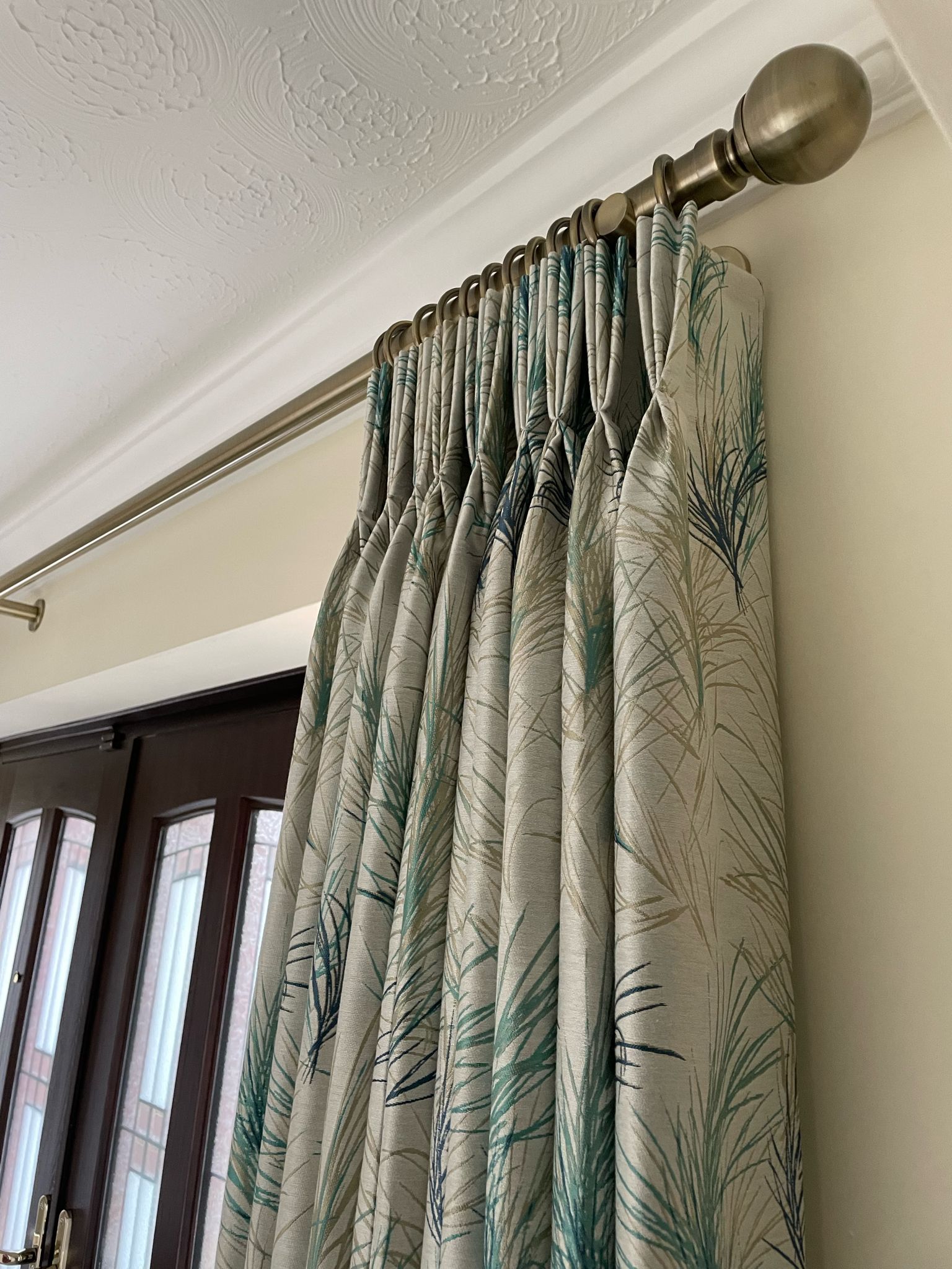 A close up of a pair of curtains hanging on a window.