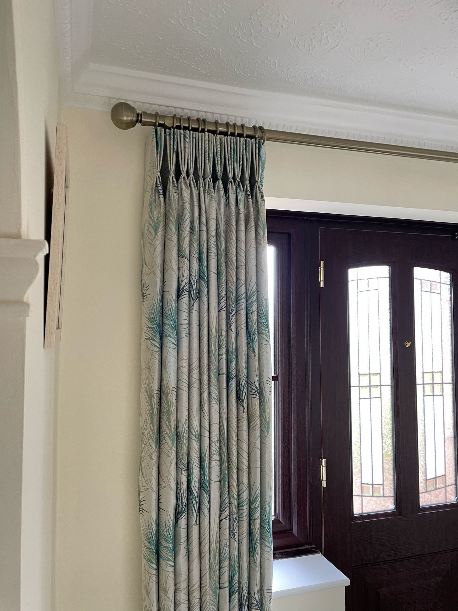 A pair of curtains hanging on a window next to a door.