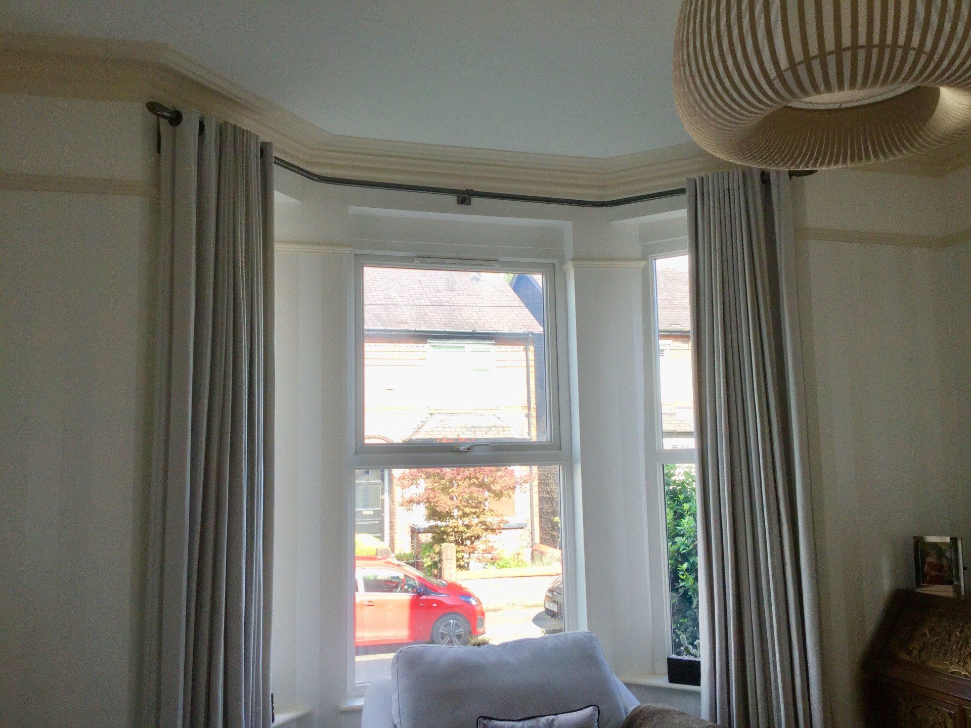 A living room with a couch and a window with curtains.