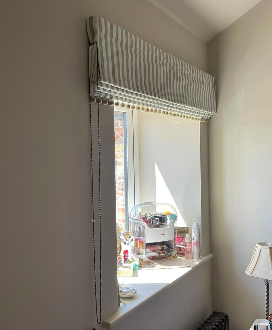 A window with a roman shade on it in a room.