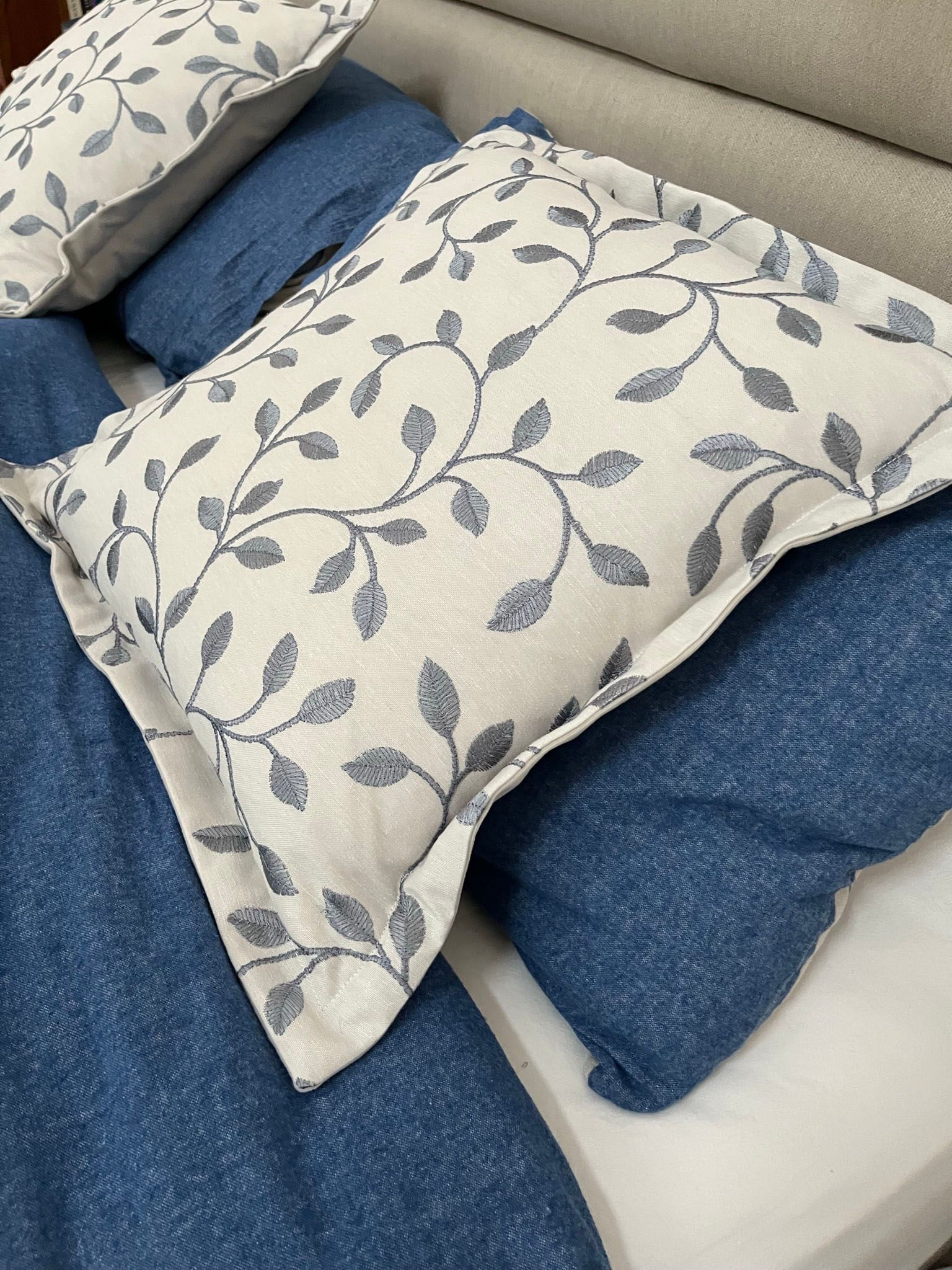 A bed with a blue comforter and pillows on it.