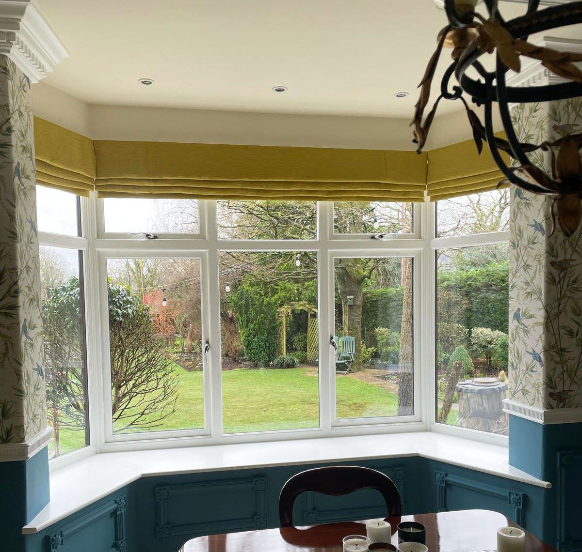 A dining room with a table and chairs and a large window