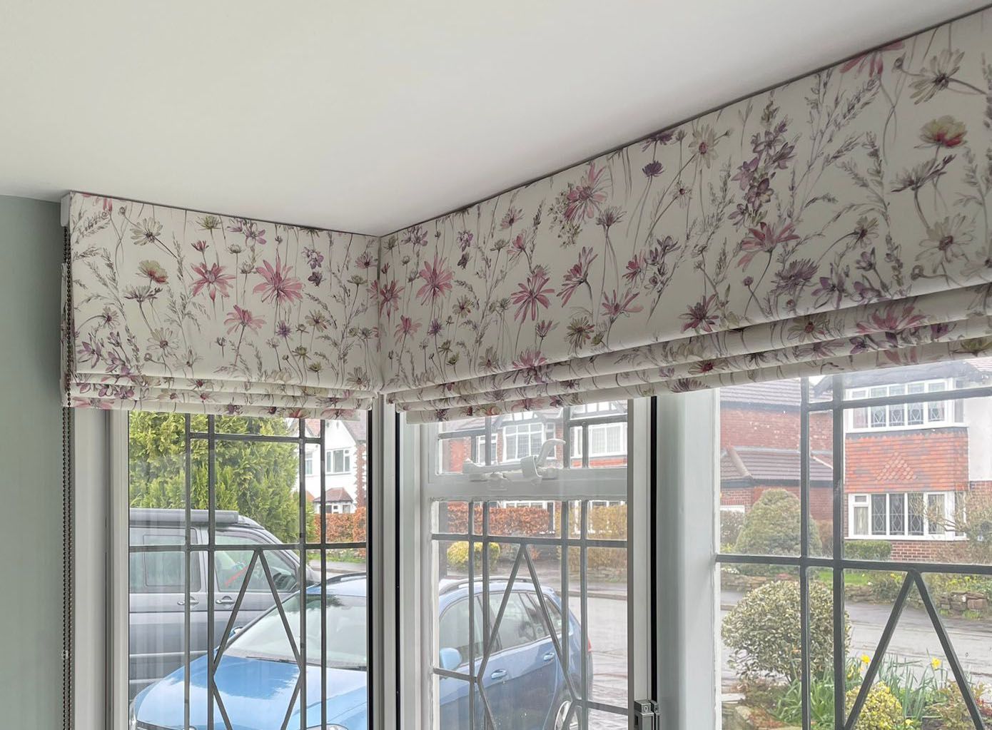 A living room with a floral roman blind on the window.