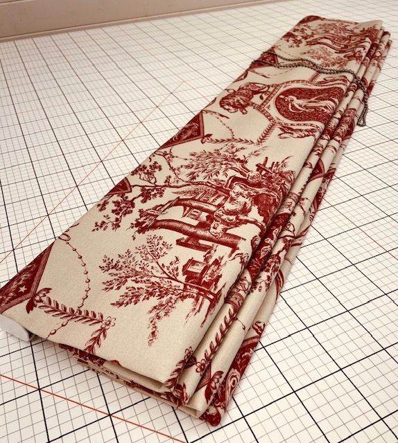 A stack of red and white fabric on a graph paper