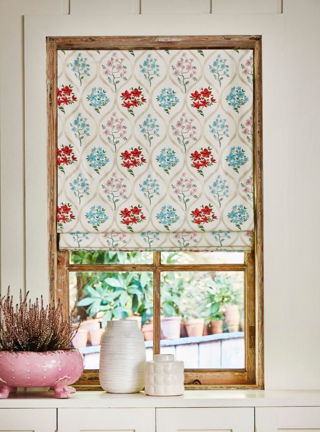 A window with a floral roman shade on it