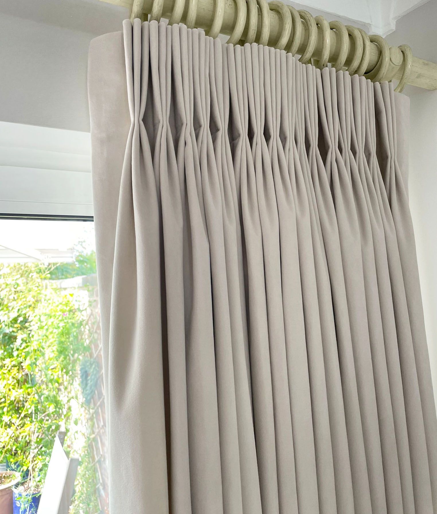 A close up of a pair of curtains hanging on a window.