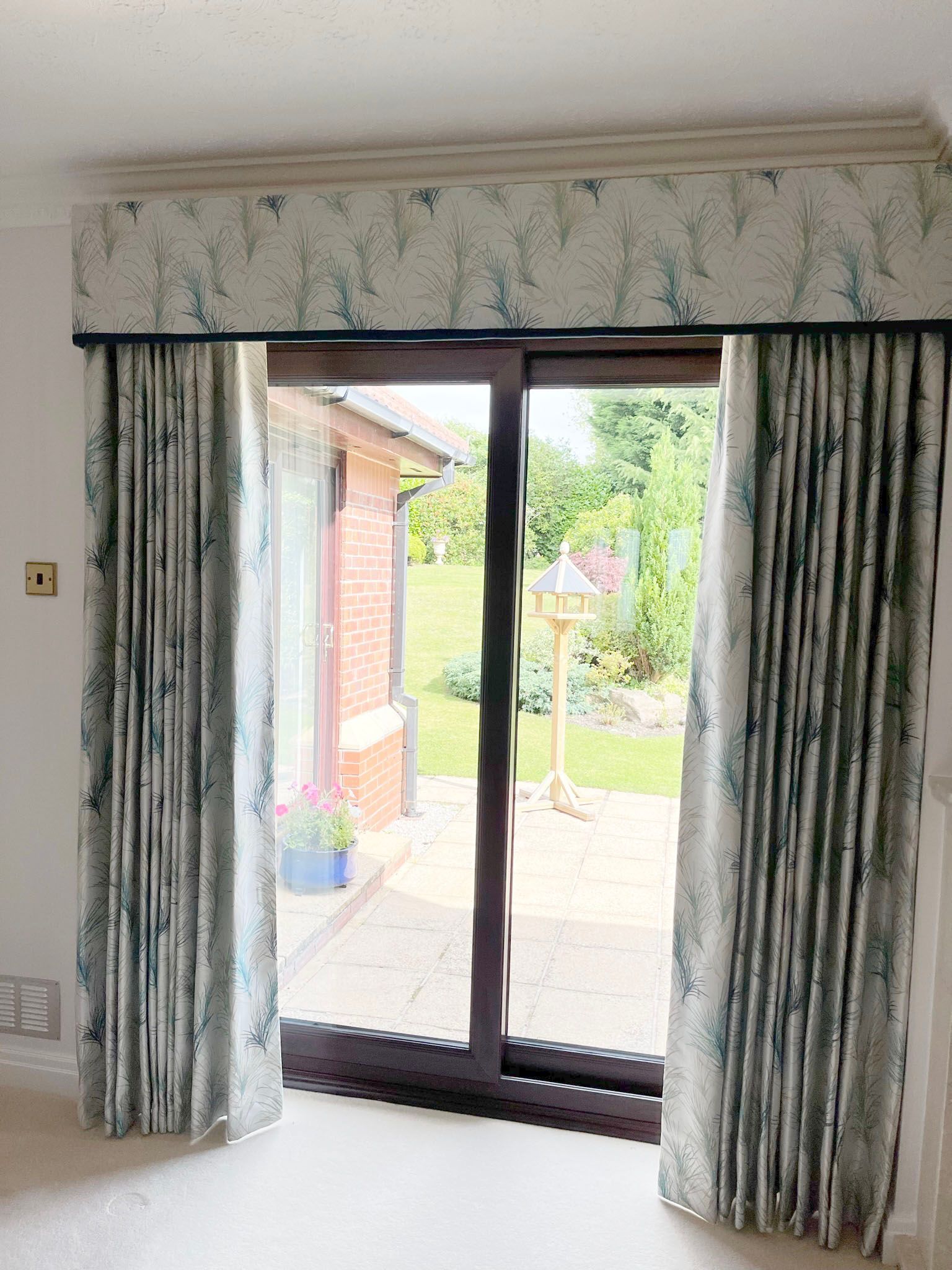 A living room with a sliding glass door and curtains.