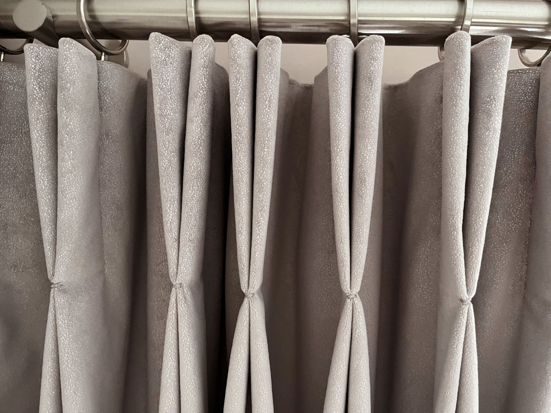 A close up of a pair of curtains hanging on a curtain rod.