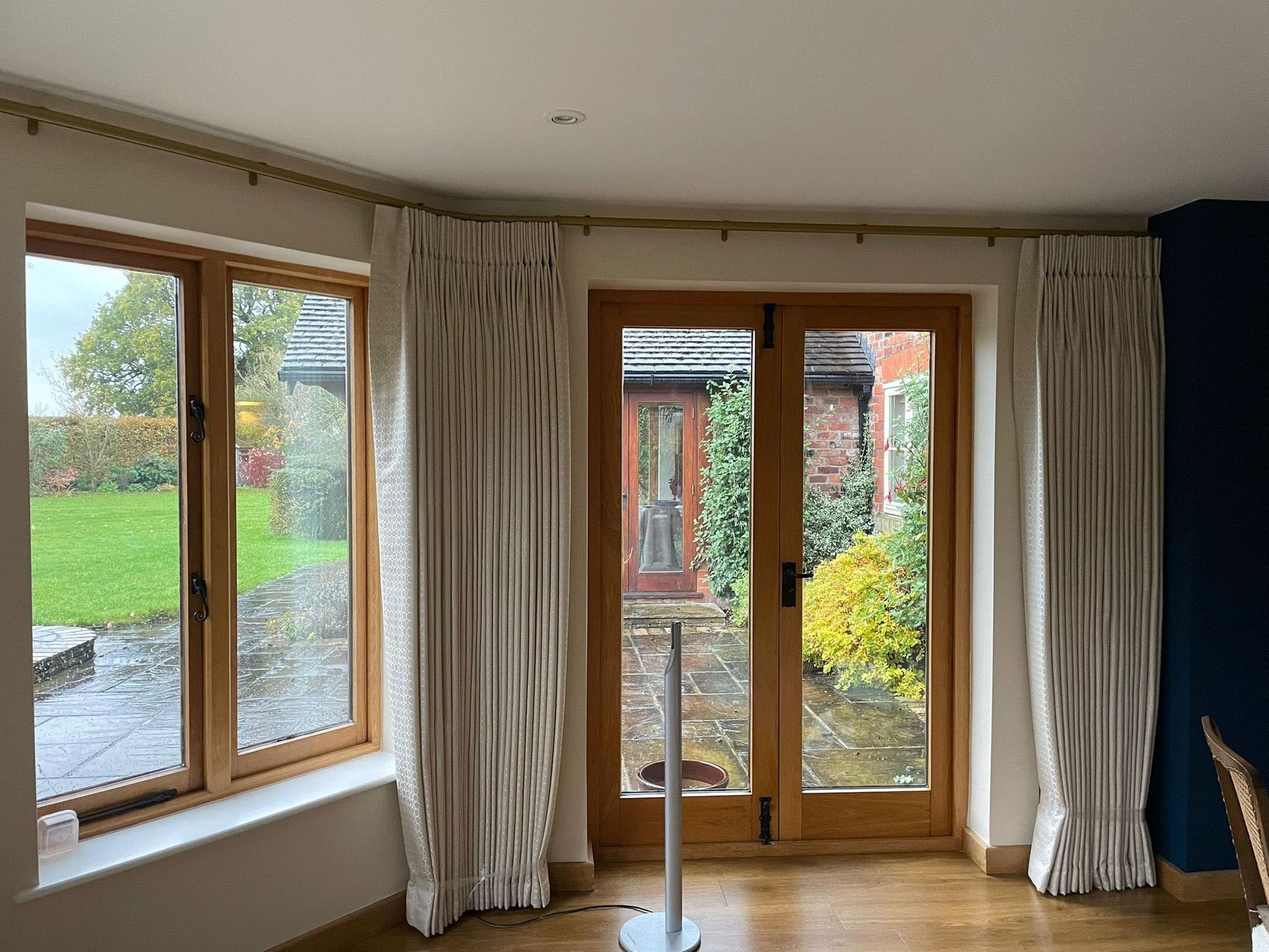 A living room with a lot of windows and curtains.