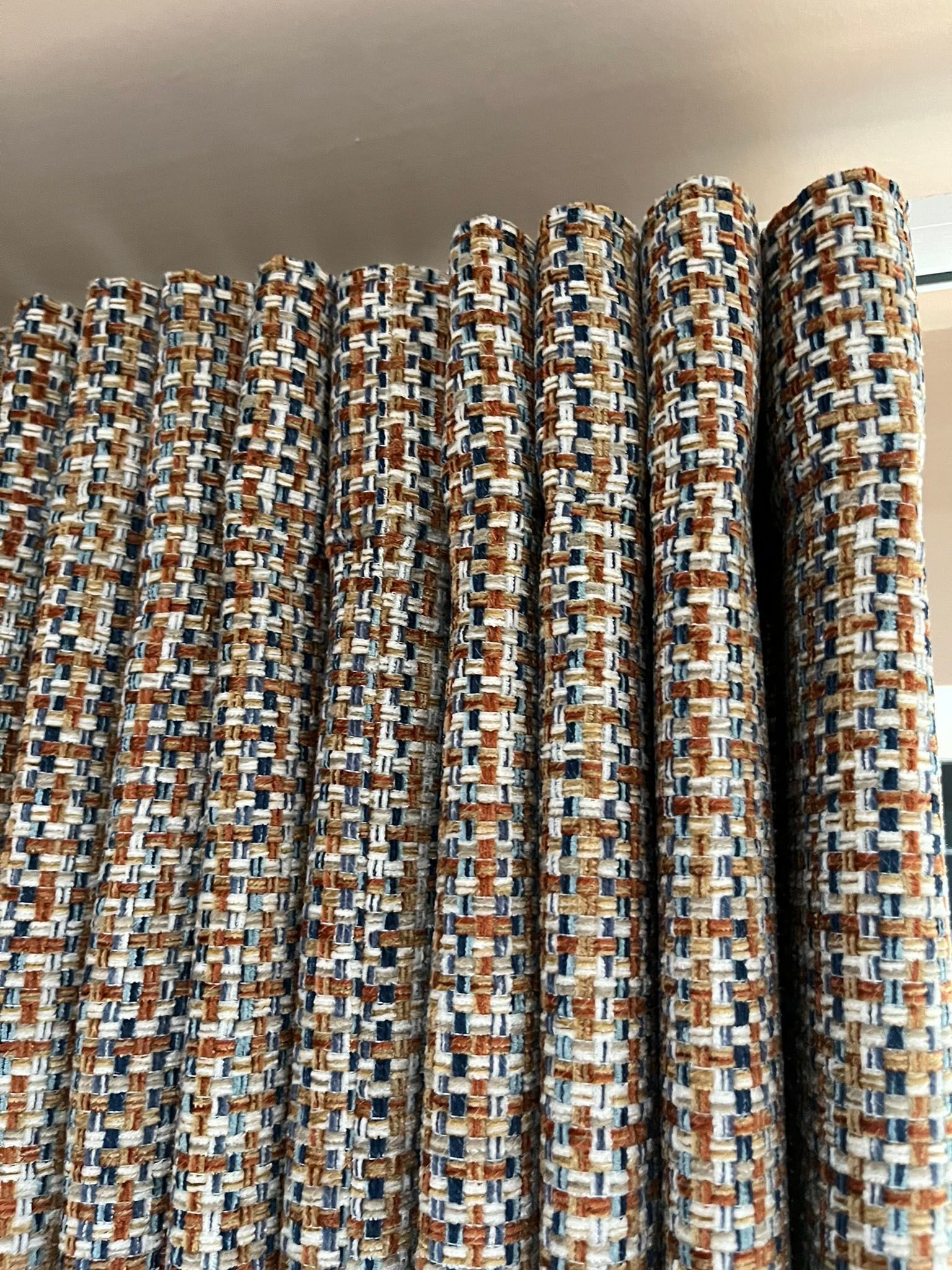 A close up of a row of curtains hanging on a window.