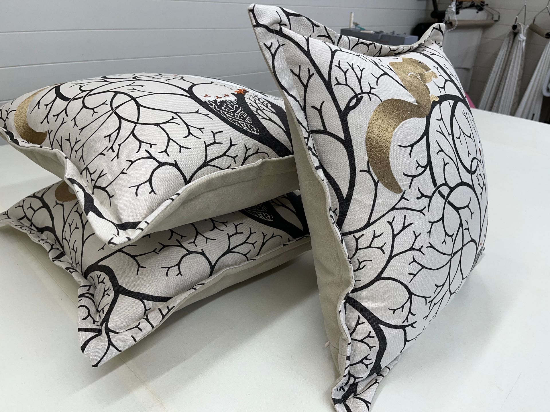 Three pillows are stacked on top of each other on a table.