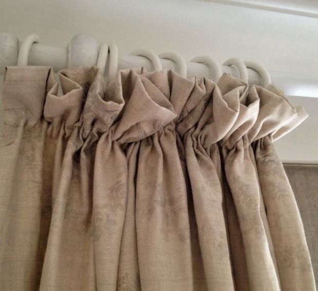 A close up of a pair of beige curtains