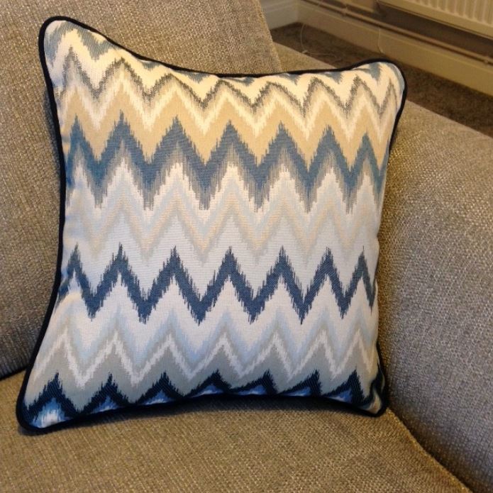 A pillow with a chevron pattern is sitting on a couch