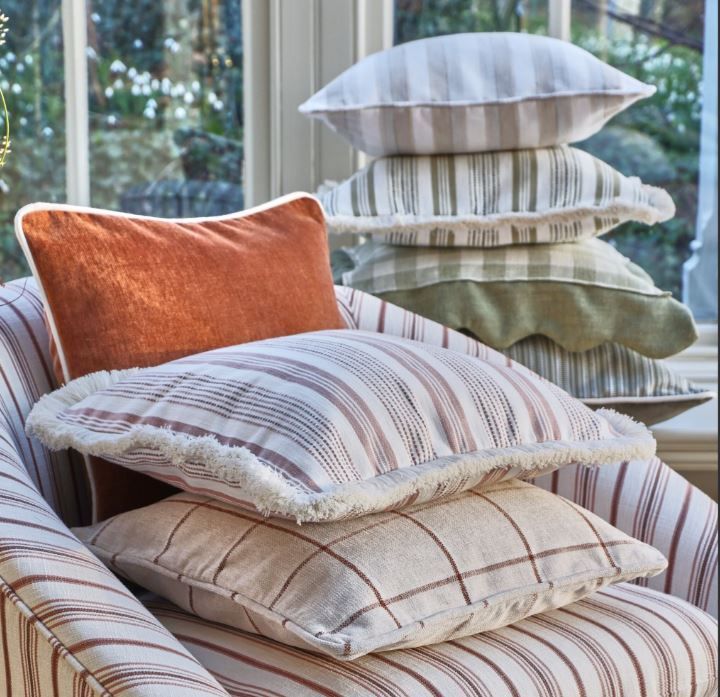 Several pillows are stacked on top of each other on a chair