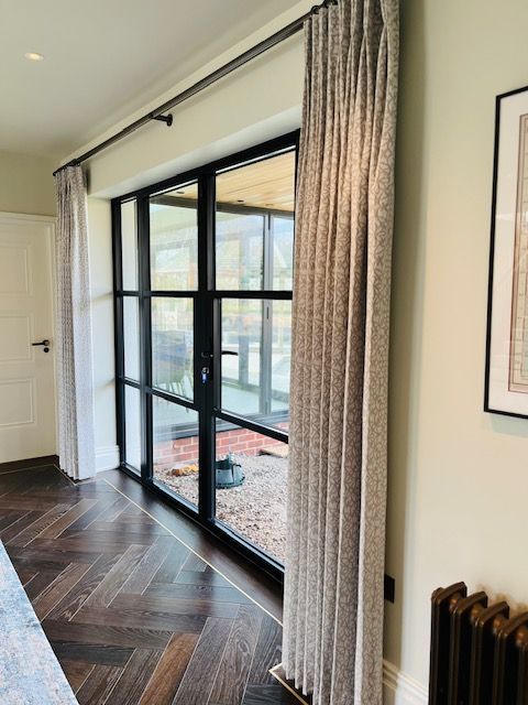 A room with a sliding glass door and curtains