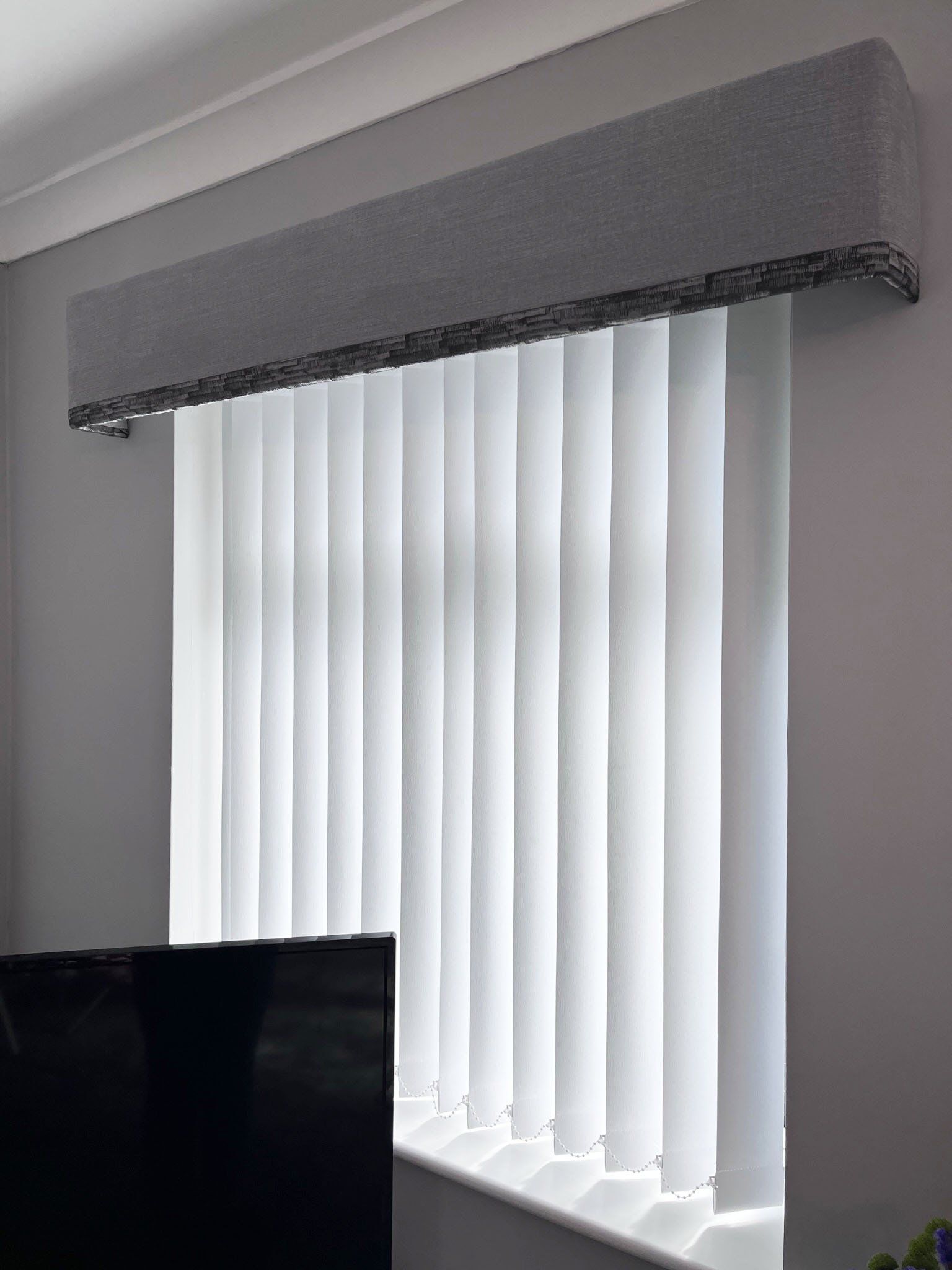 A pelmet with a contrast trim and vertical blinds