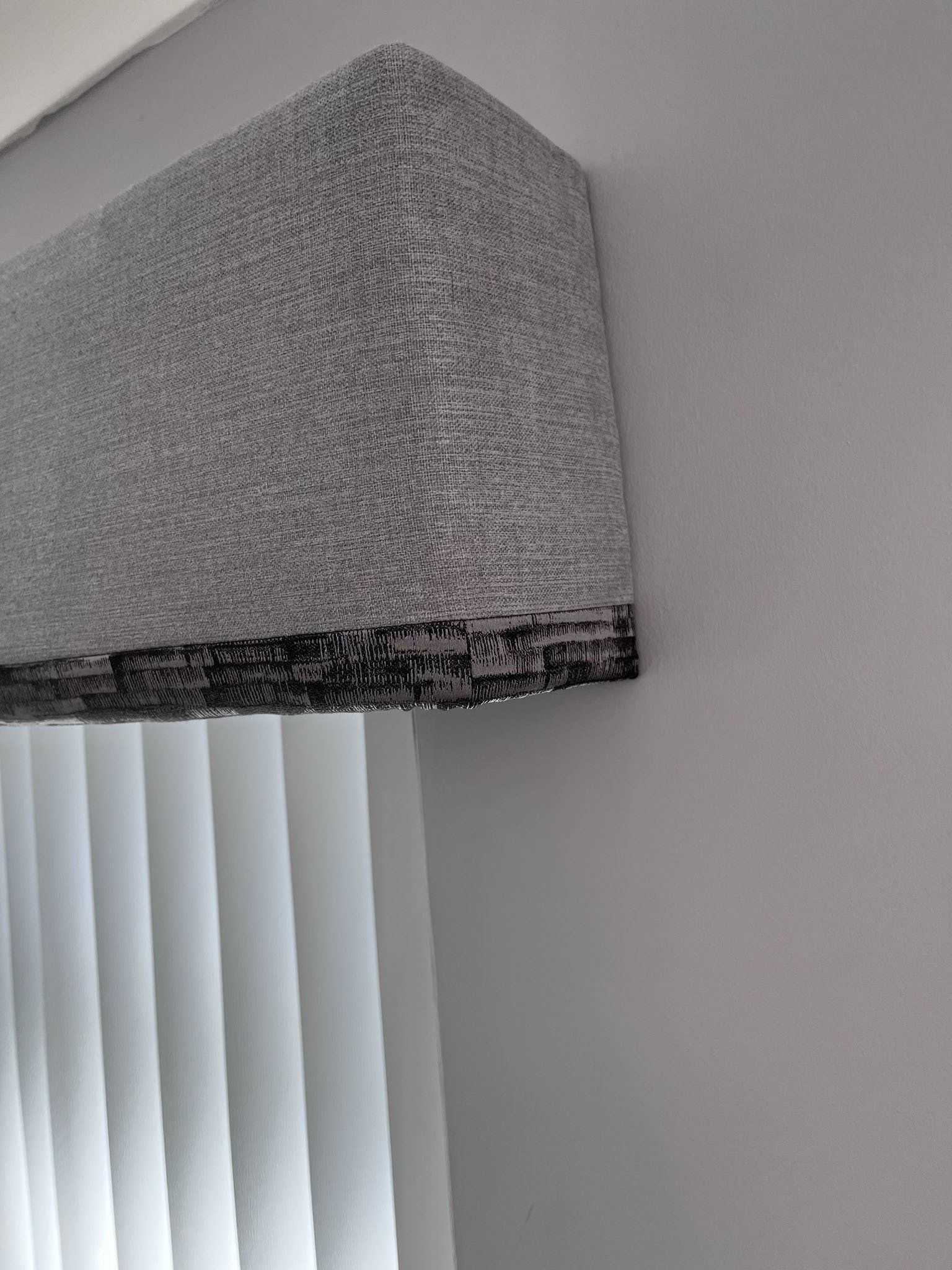 A pelmet with a contrast trim and vertical blinds