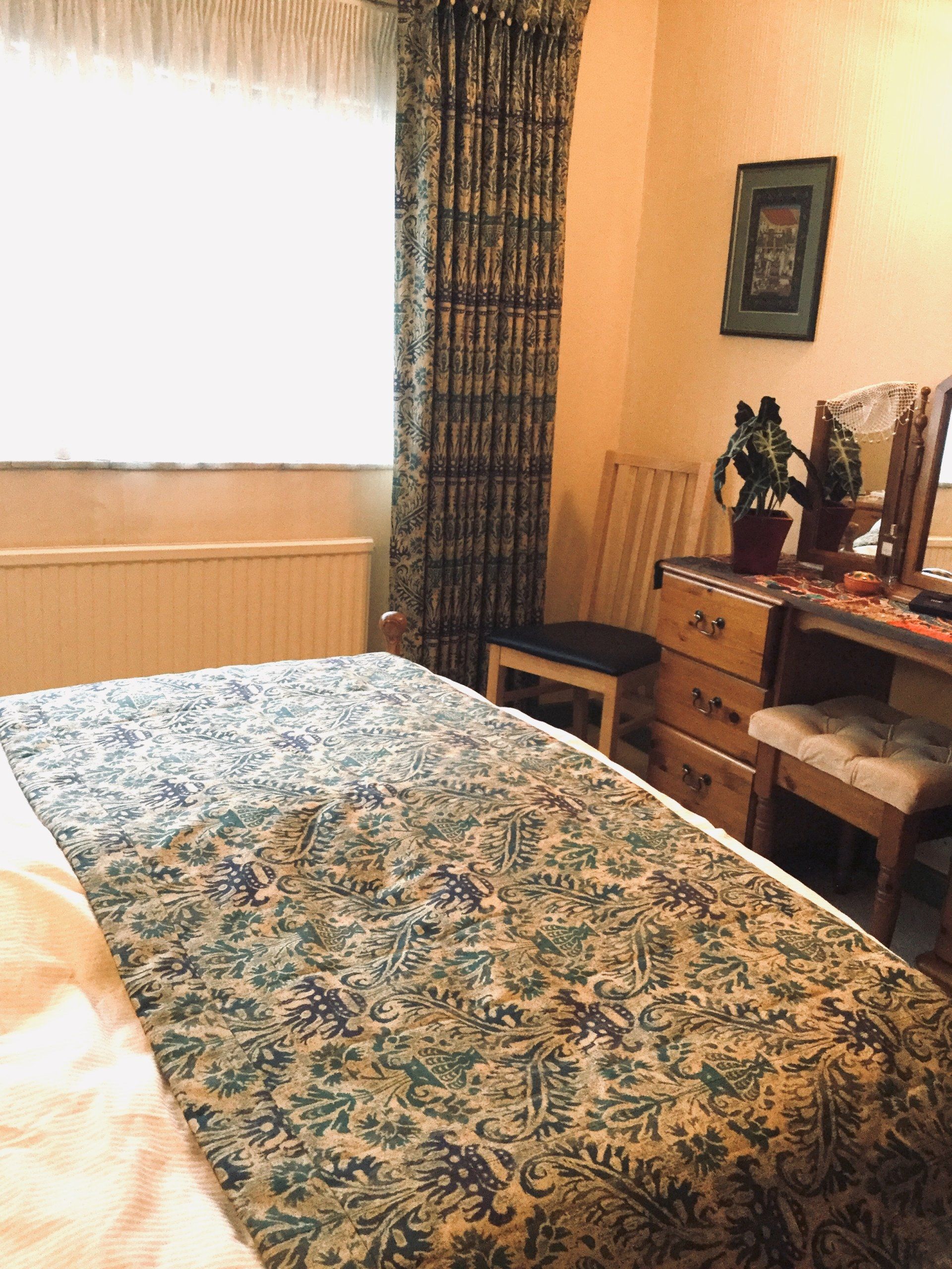 A bedroom with a quilted bed runner