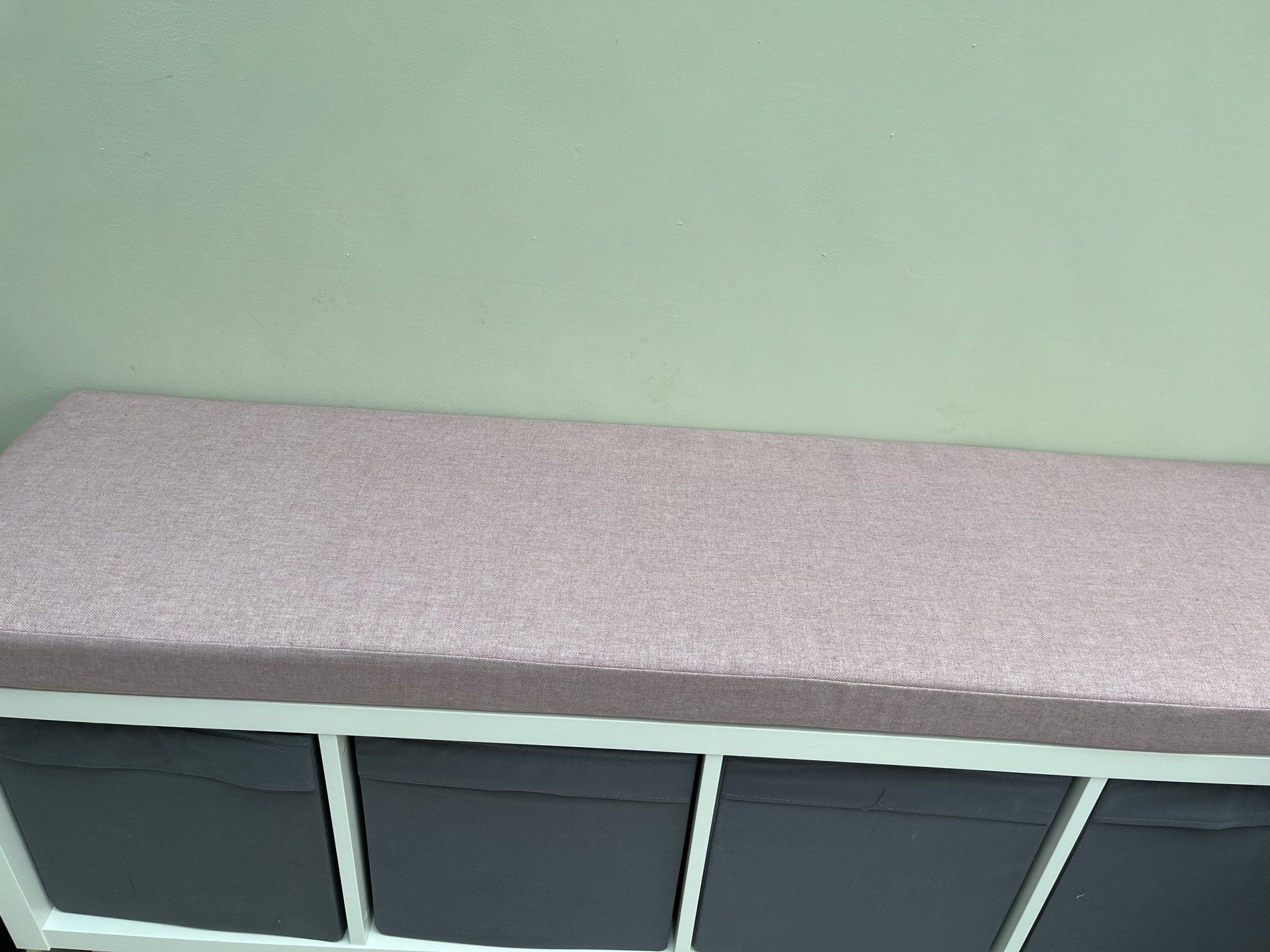 A bench with a pink cushion on top of it