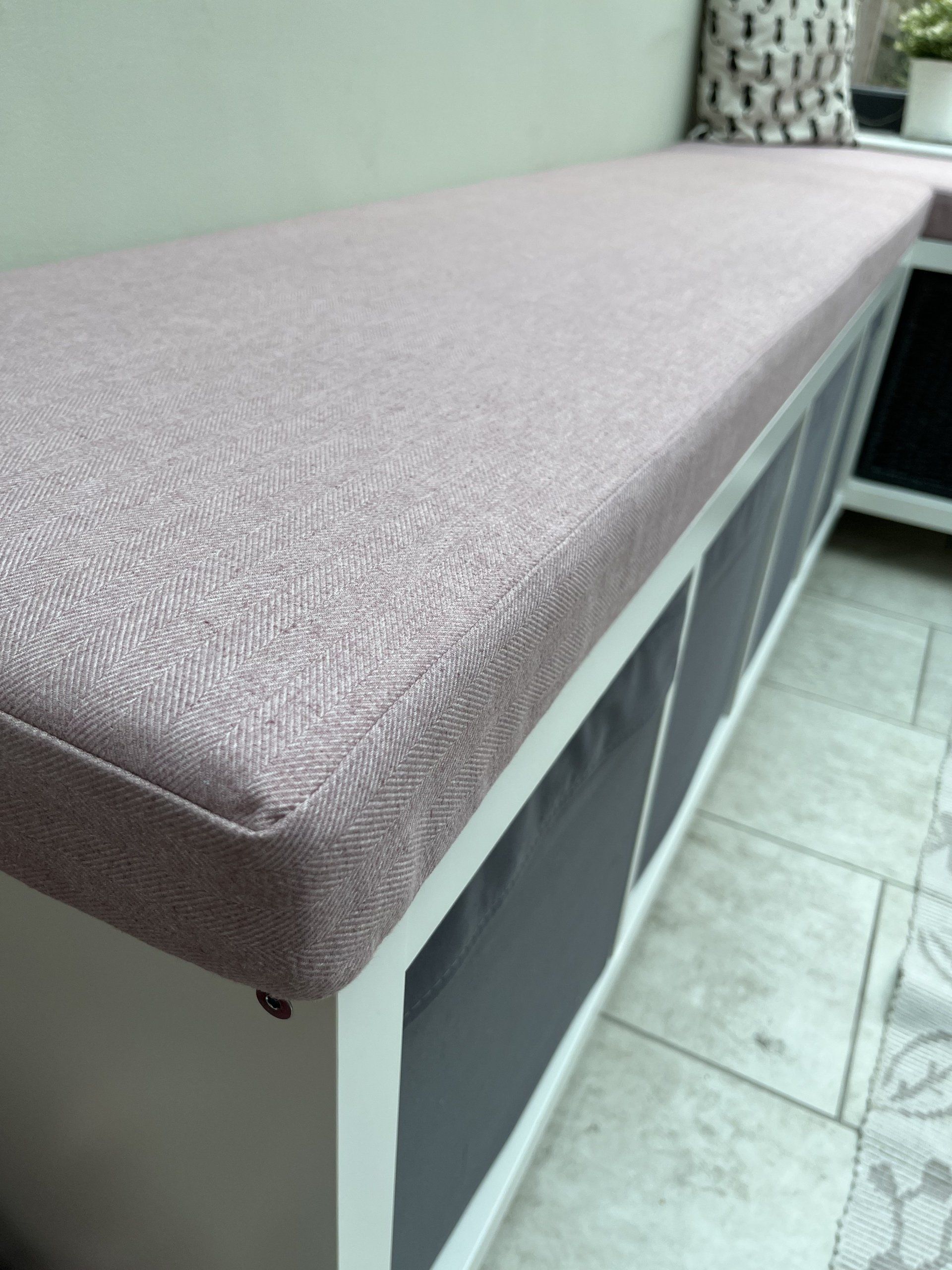 A bench with a pink cushion on top of it