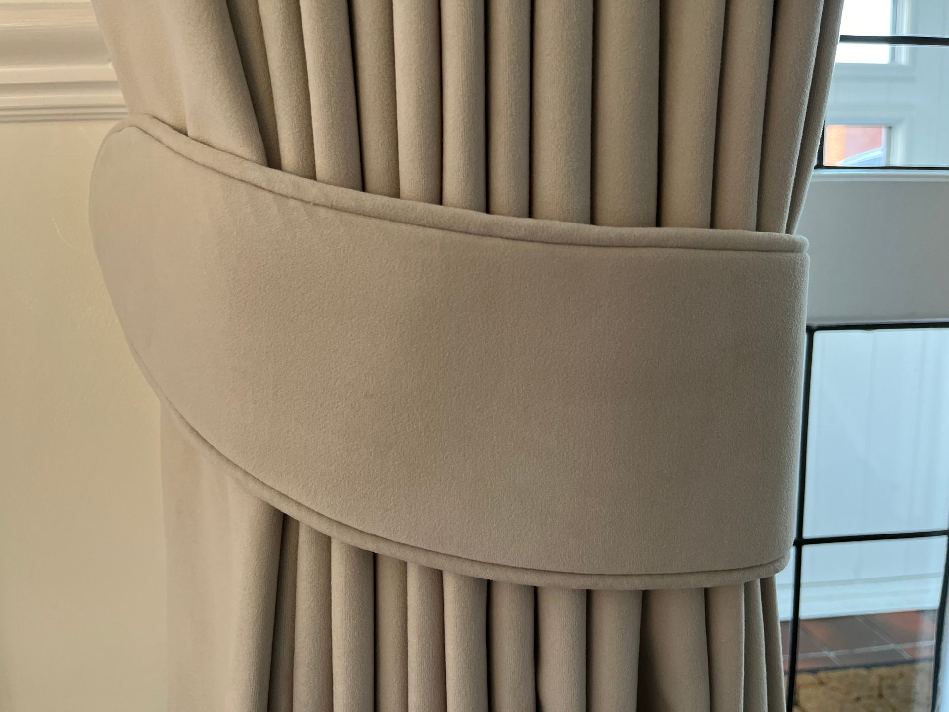 A close up of a curtain tie back on a window.