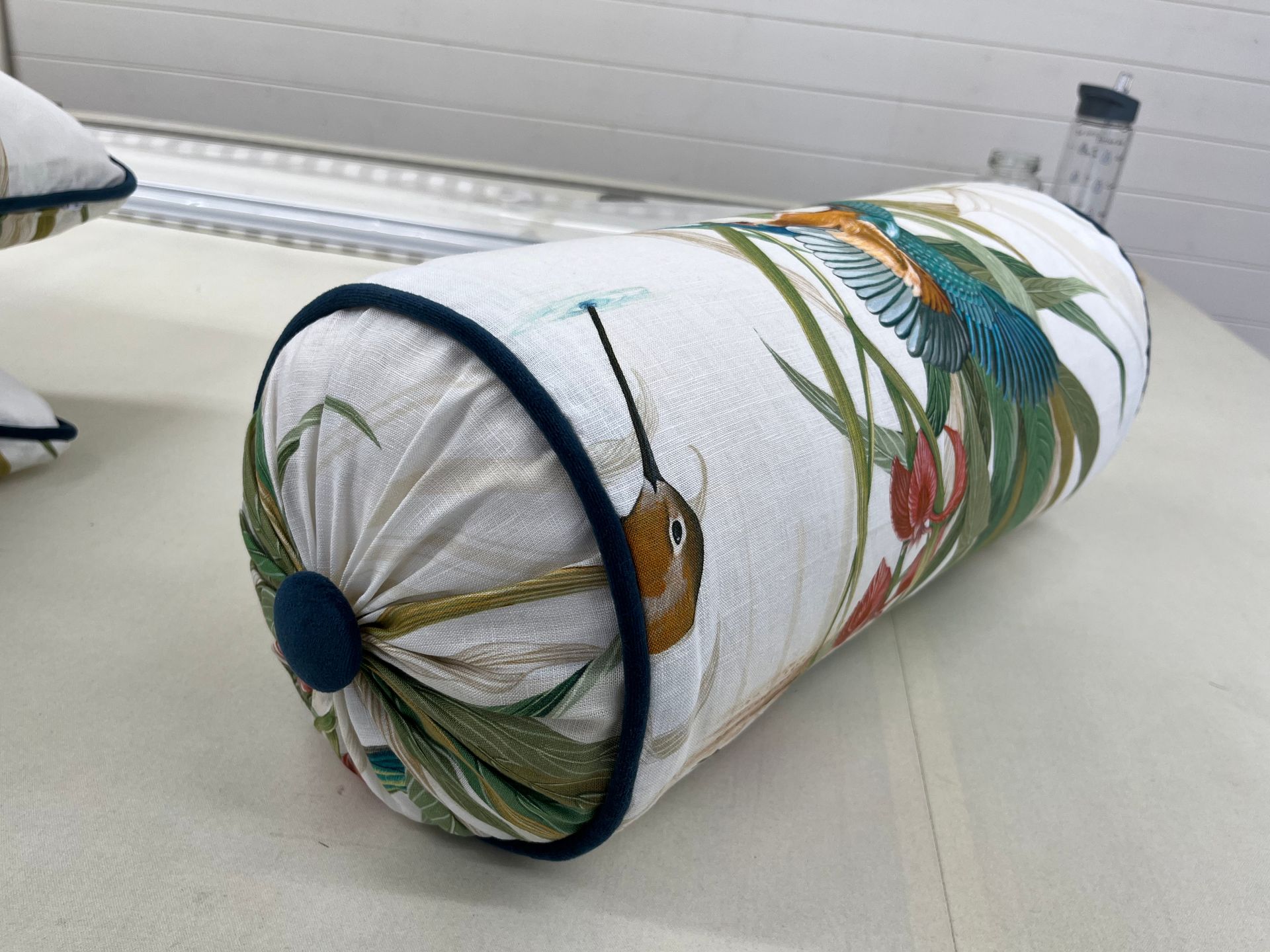 A white pillow with a bird on it is sitting on a table.