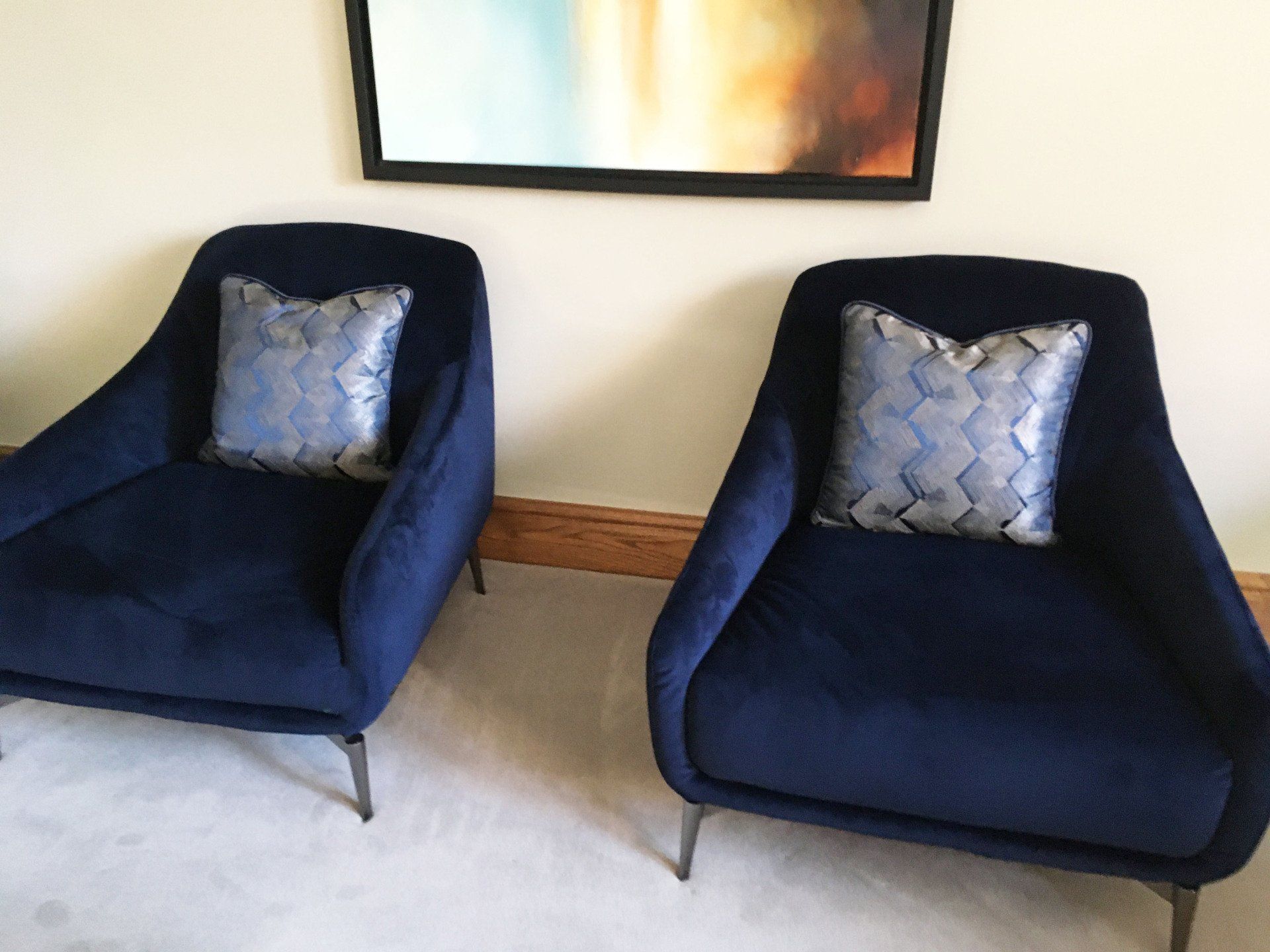 Two blue chairs with pillows on them in a living room