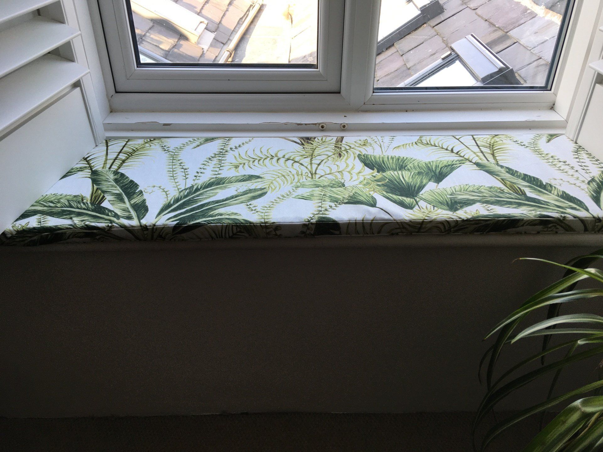 A window sill with a green and white floral pattern on it.