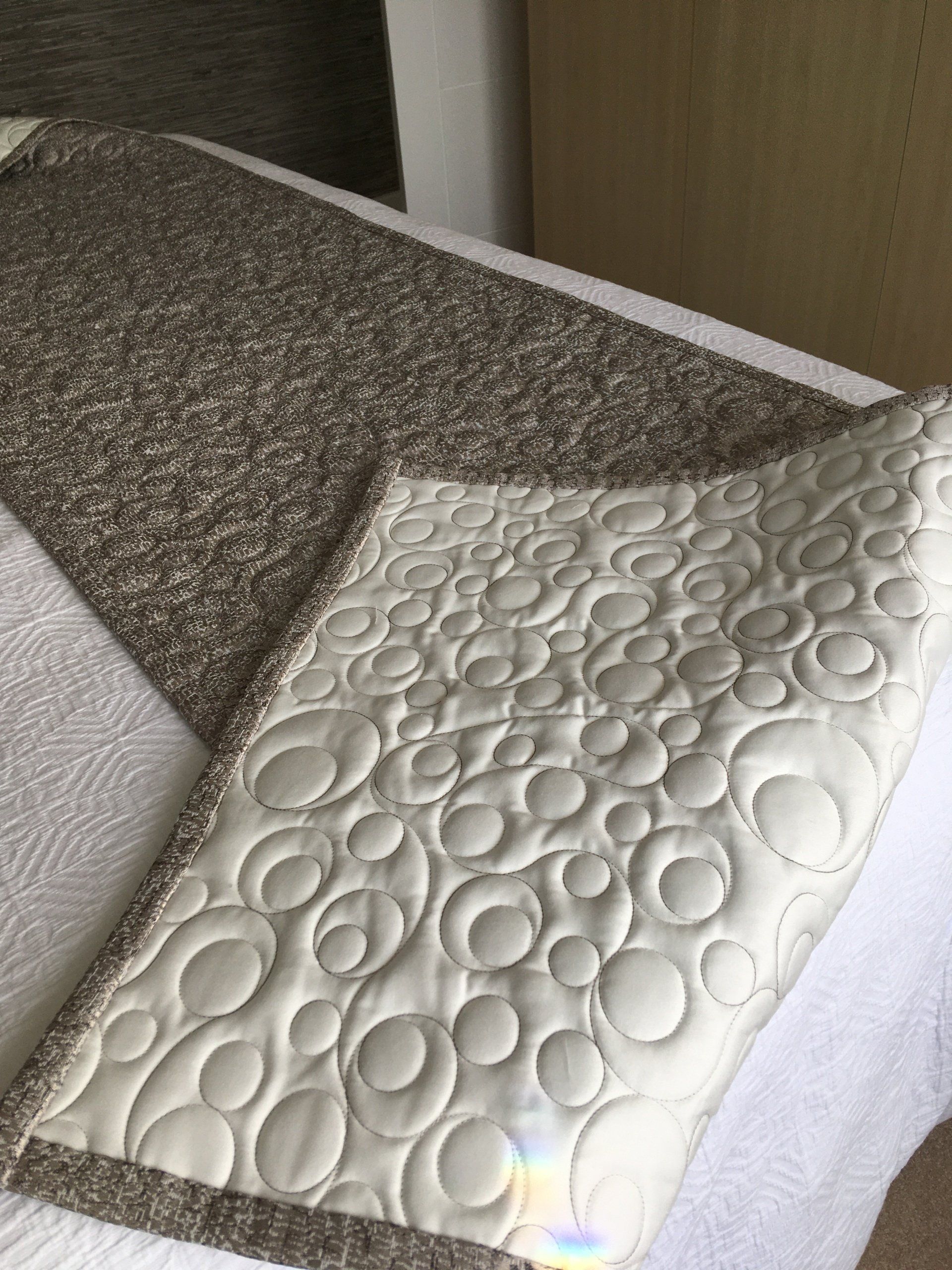 A bed with a quilt and a pillow on it.