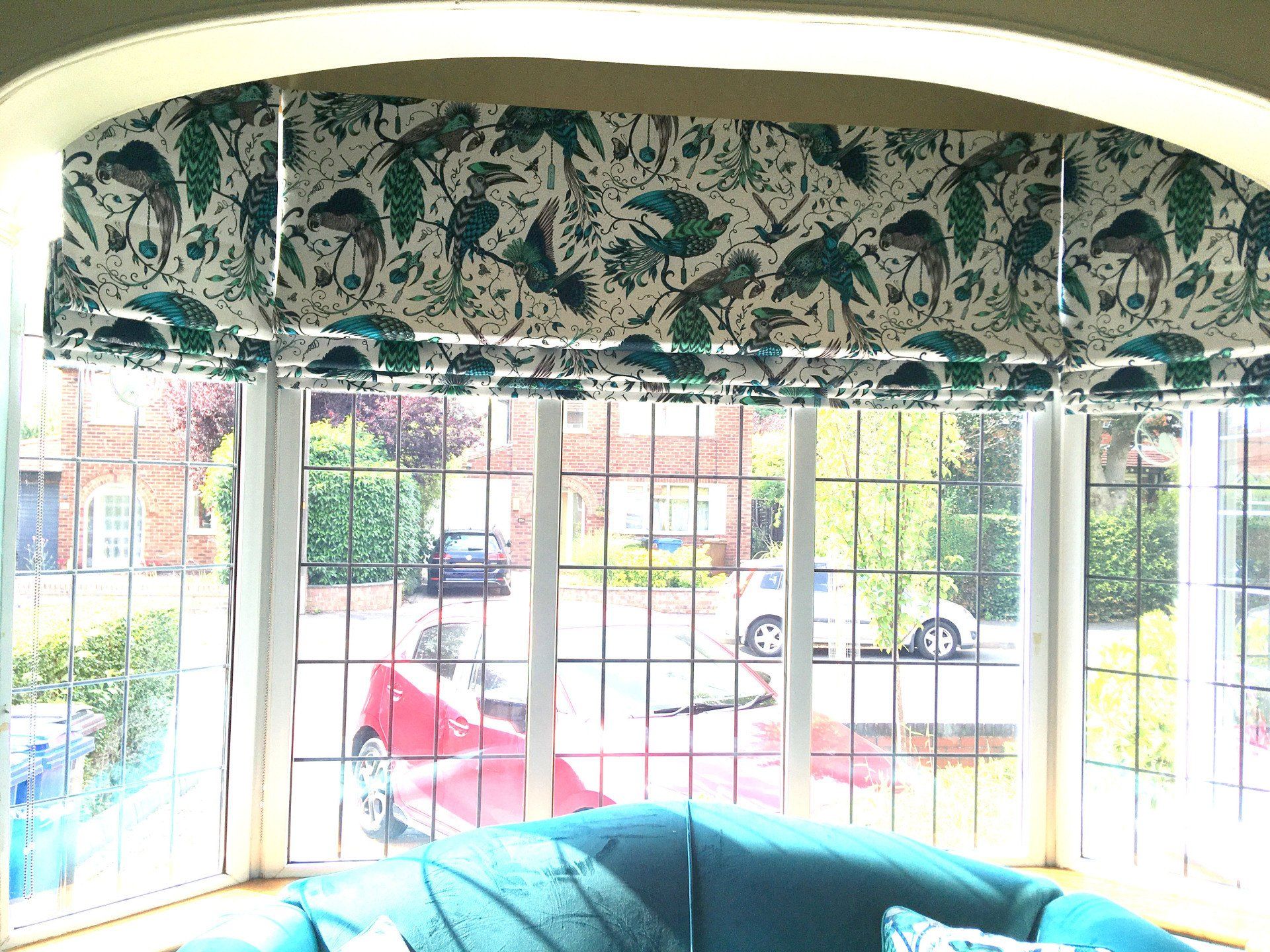 A living room with a blue couch and a large window.