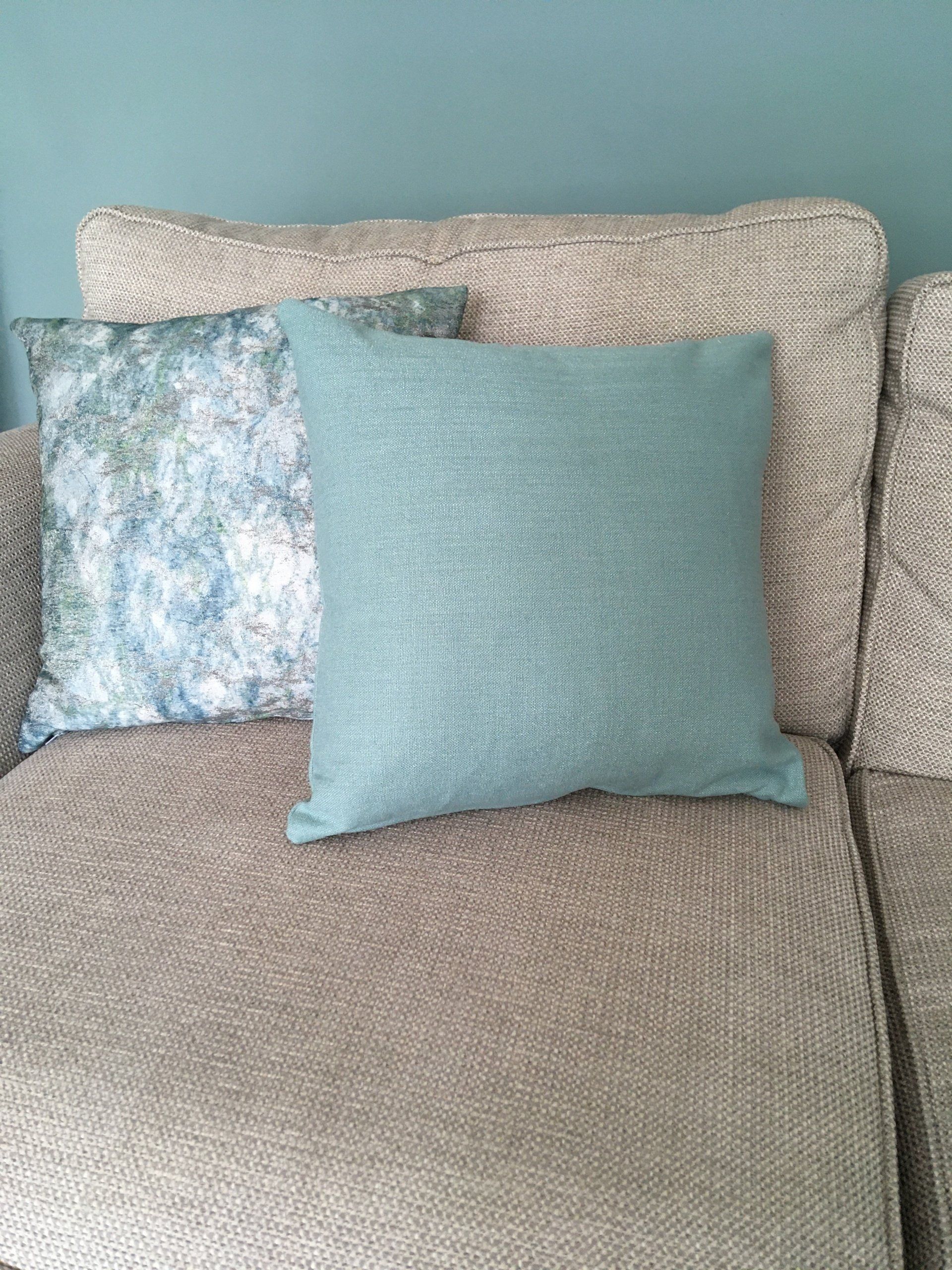 Two pillows are sitting on a couch next to each other.