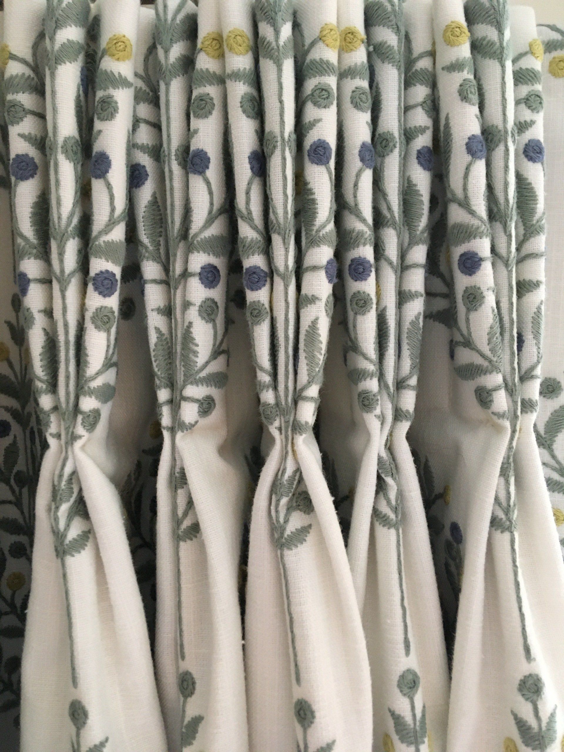 A close up of a pair of curtains with a floral pattern on them.