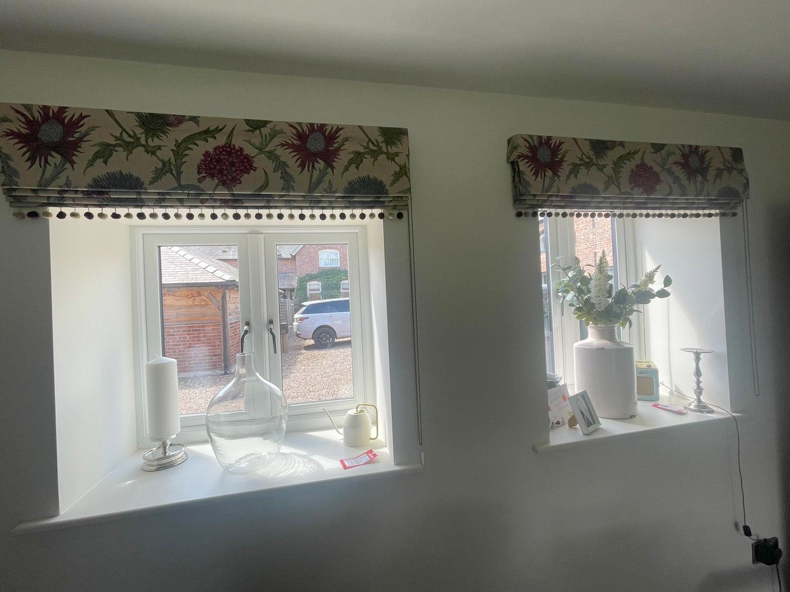 A couple of windows with curtains on them in a room.