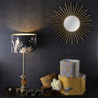 A table with a lamp and a mirror on it