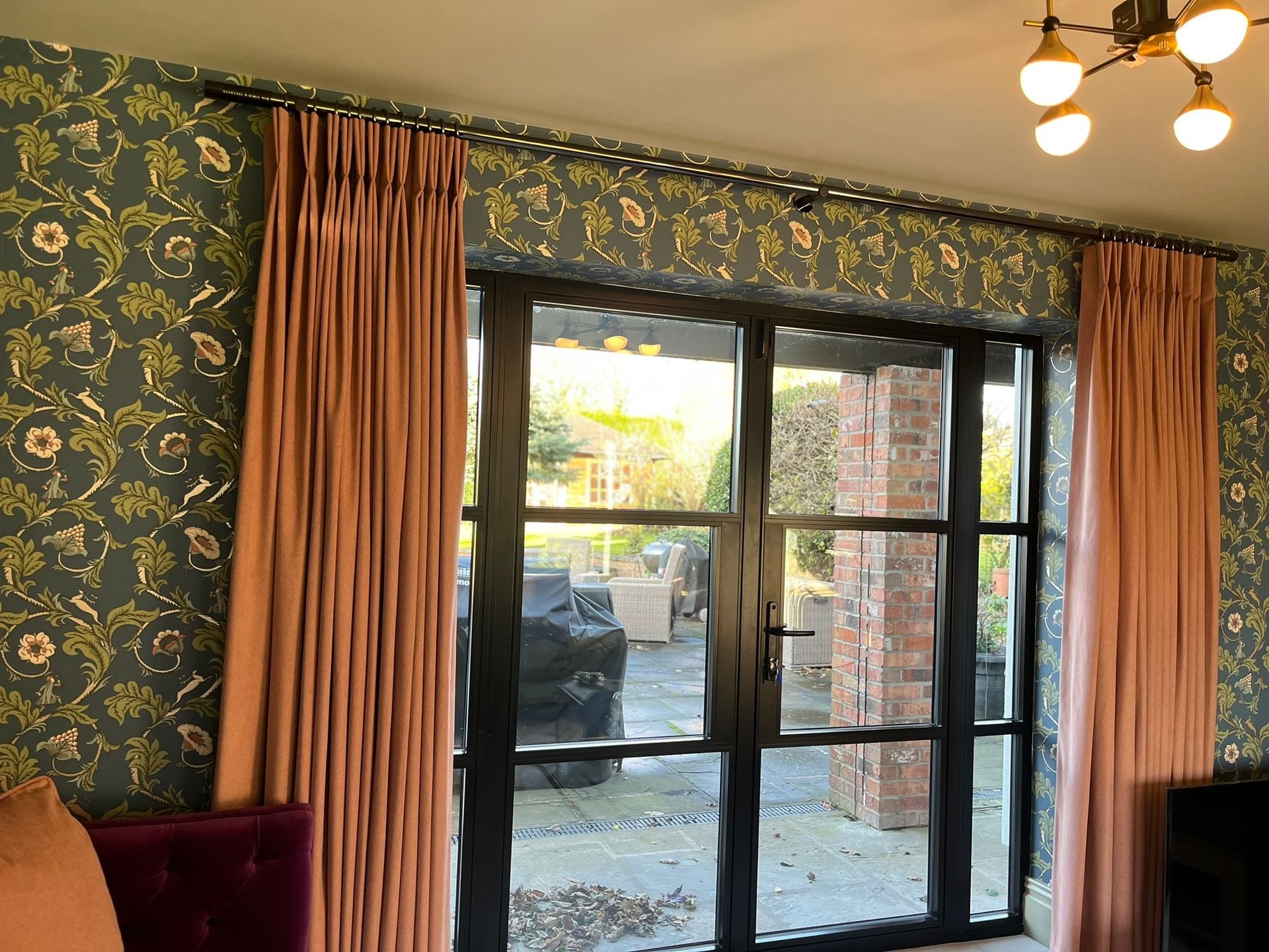 A living room with a sliding glass door and pink curtains.