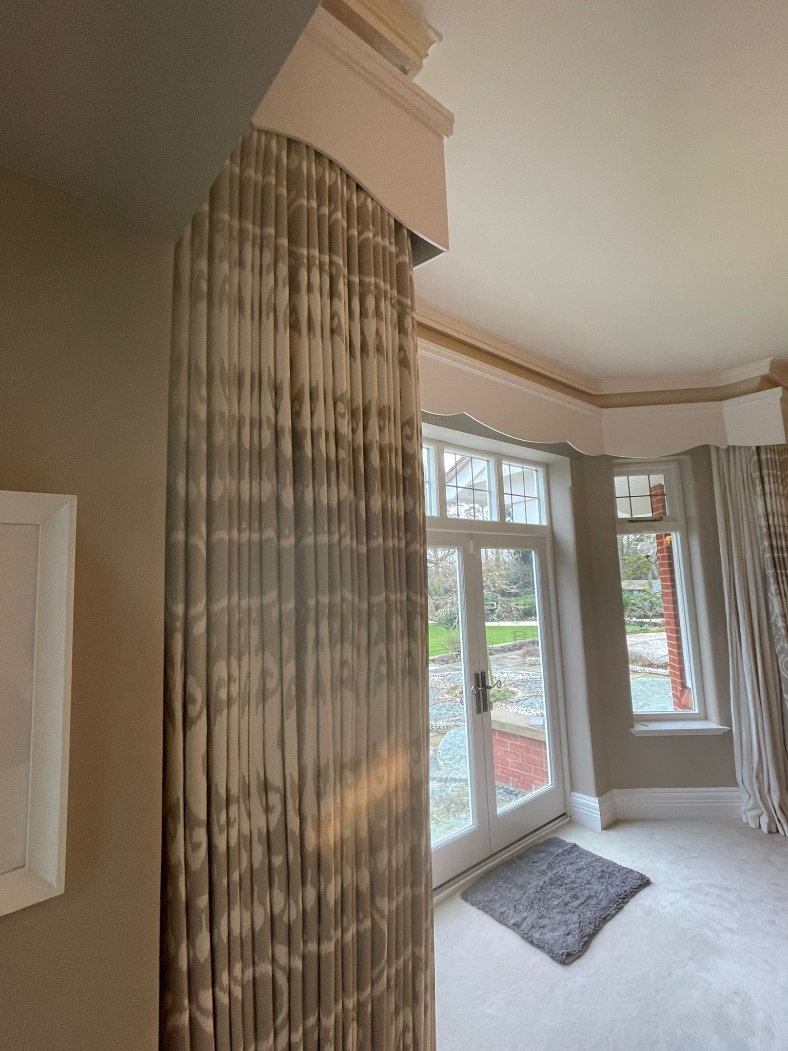 A bedroom with a sliding glass door and a rug on the floor.