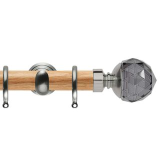 A wooden curtain rod with a crystal ball on top