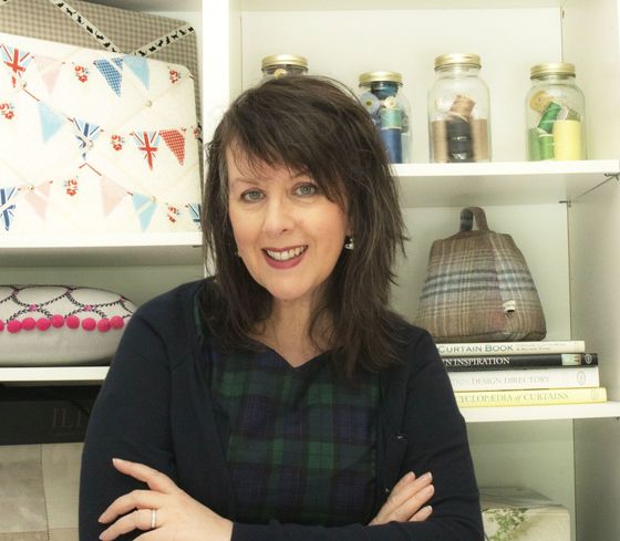 A woman is standing in front of a shelf with jars on it