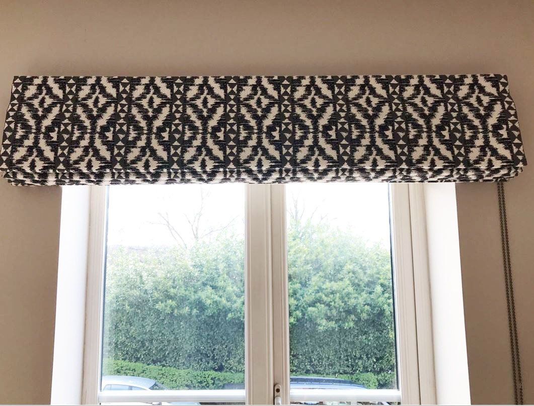 A window with a black and white curtain on it