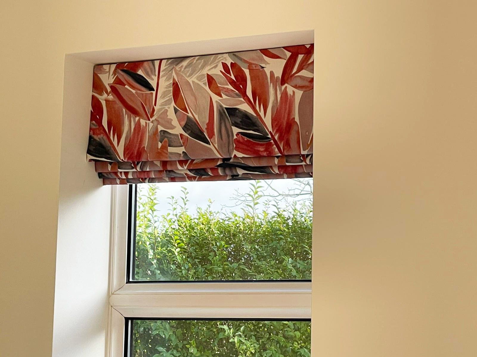 A window with a red and black blind on it.