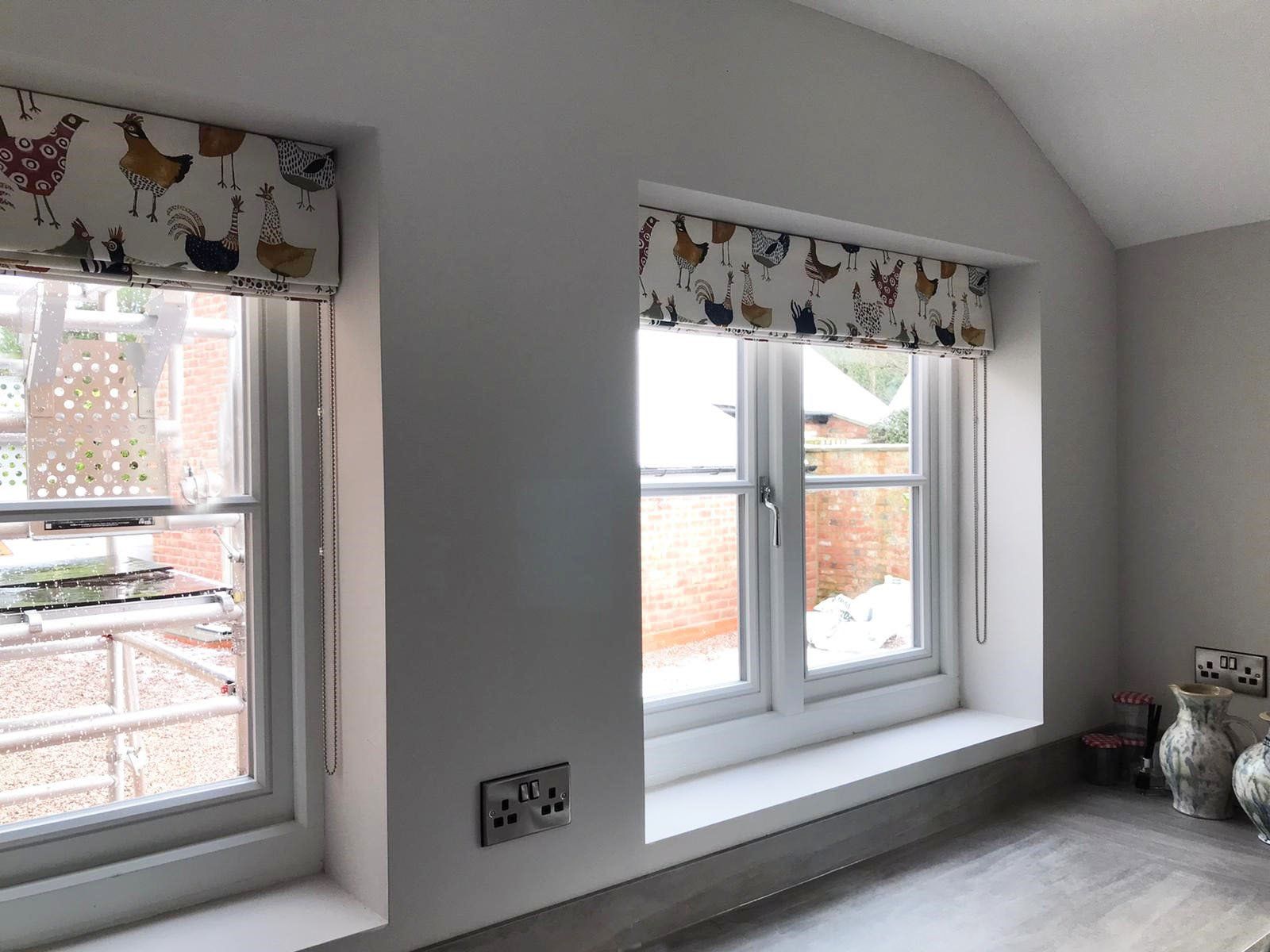 There are two windows in the room with curtains on them.